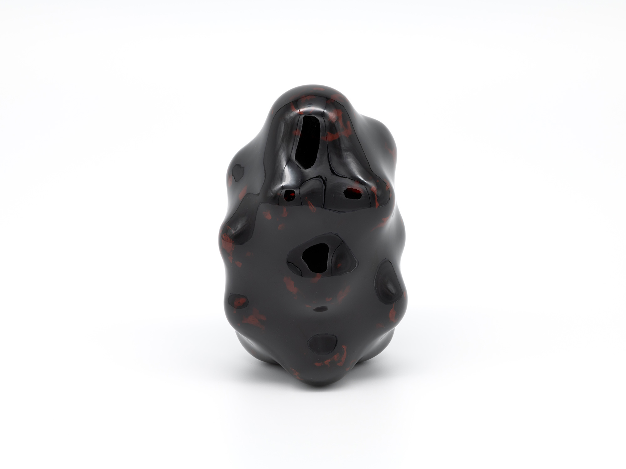 View of Untitled by Genta Ishizuka, an organic dark lacquer sculpture with a highly polished surface....
