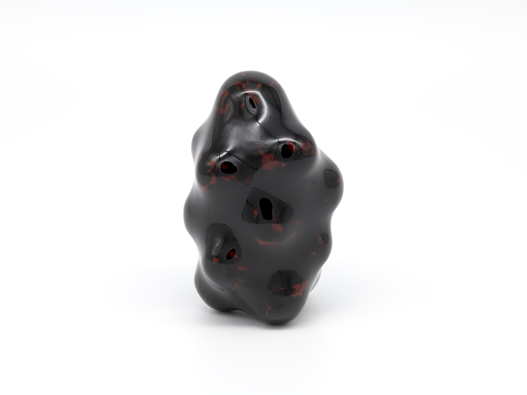 View of Untitled by Genta Ishizuka, an organic dark lacquer sculpture with a highly polished surface....