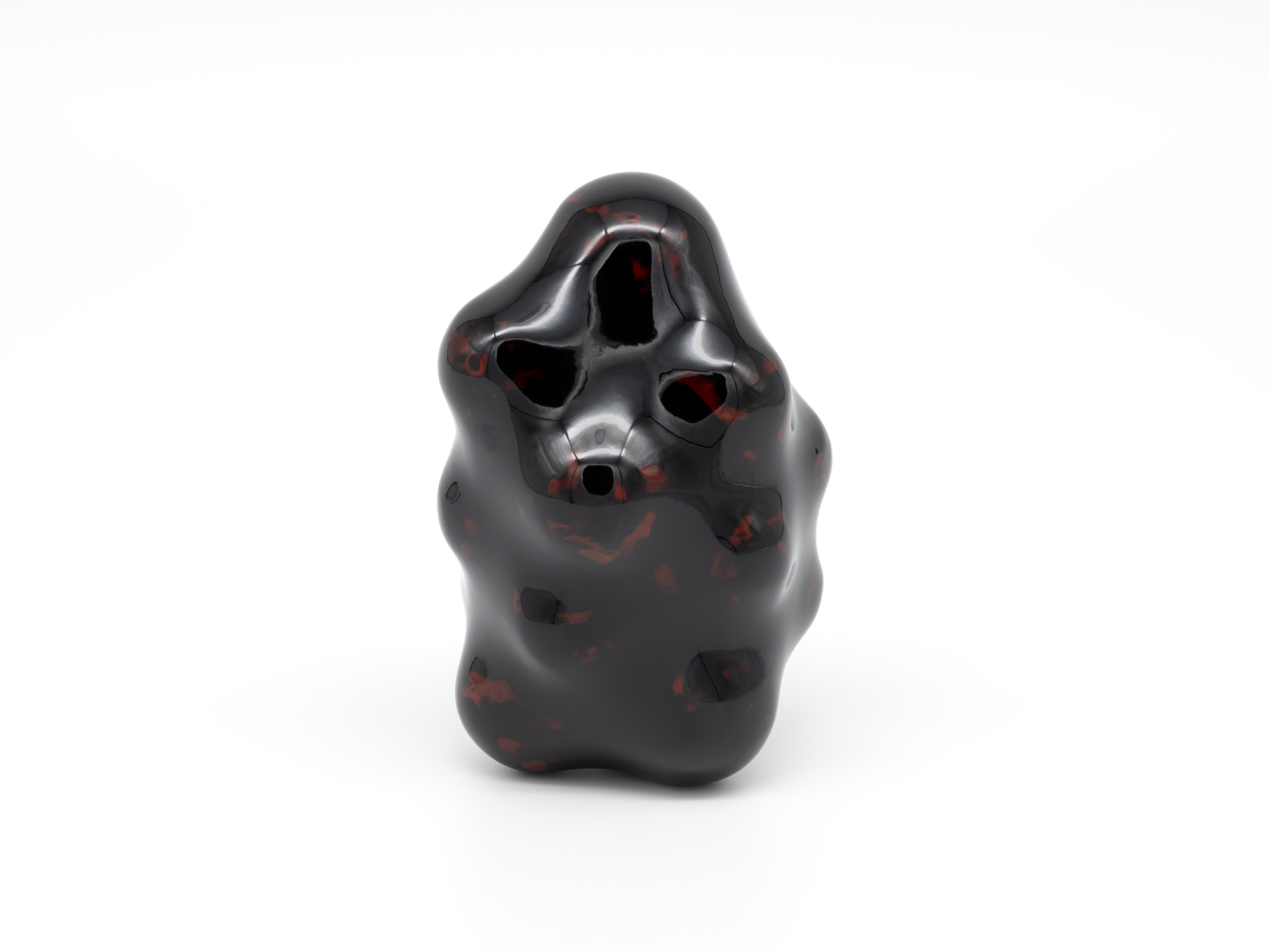 View of Untitled by Genta Ishizuka, an organic dark lacquer sculpture with a highly polished surface....