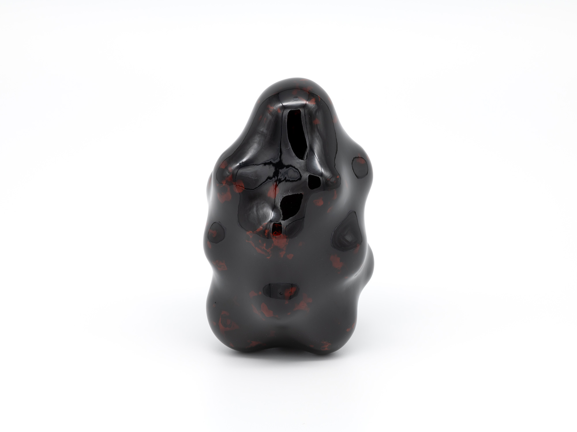 View of Untitled by Genta Ishizuka, an organic dark lacquer sculpture with a highly polished surface....