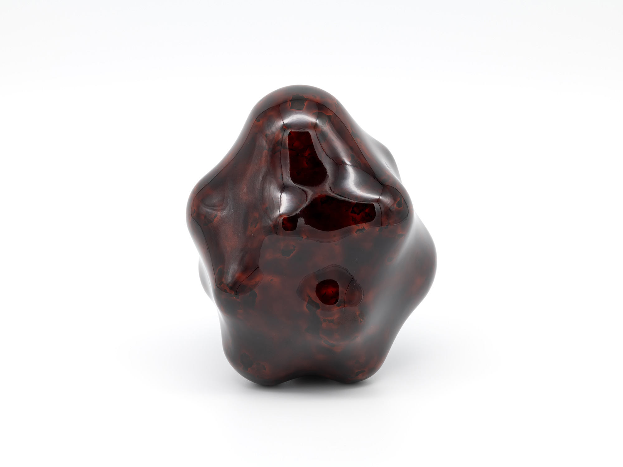 View of Untitled by Genta Ishizuka, an organic dark lacquer sculpture with a highly polished surface....