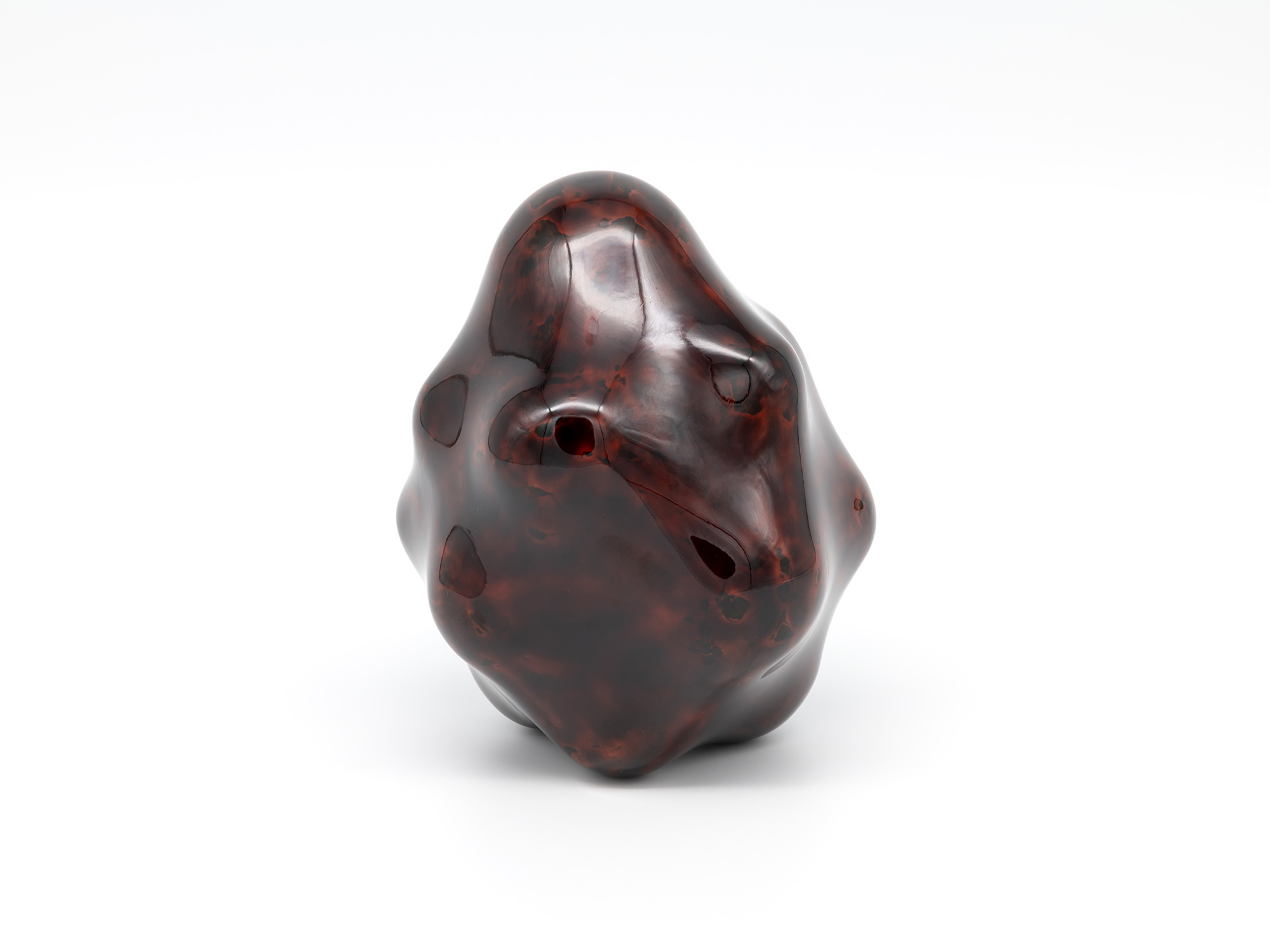 View of Untitled by Genta Ishizuka, an organic dark lacquer sculpture with a highly polished surface....