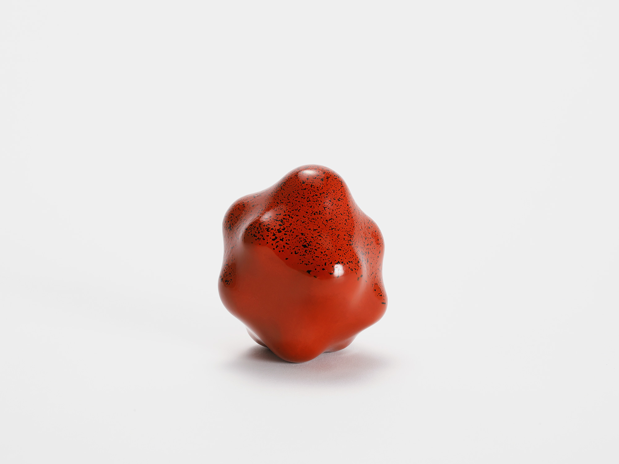 View of Untitled (Powder) by Genta Ishizuka, an organic red lacquer sculpture with a smooth matte...