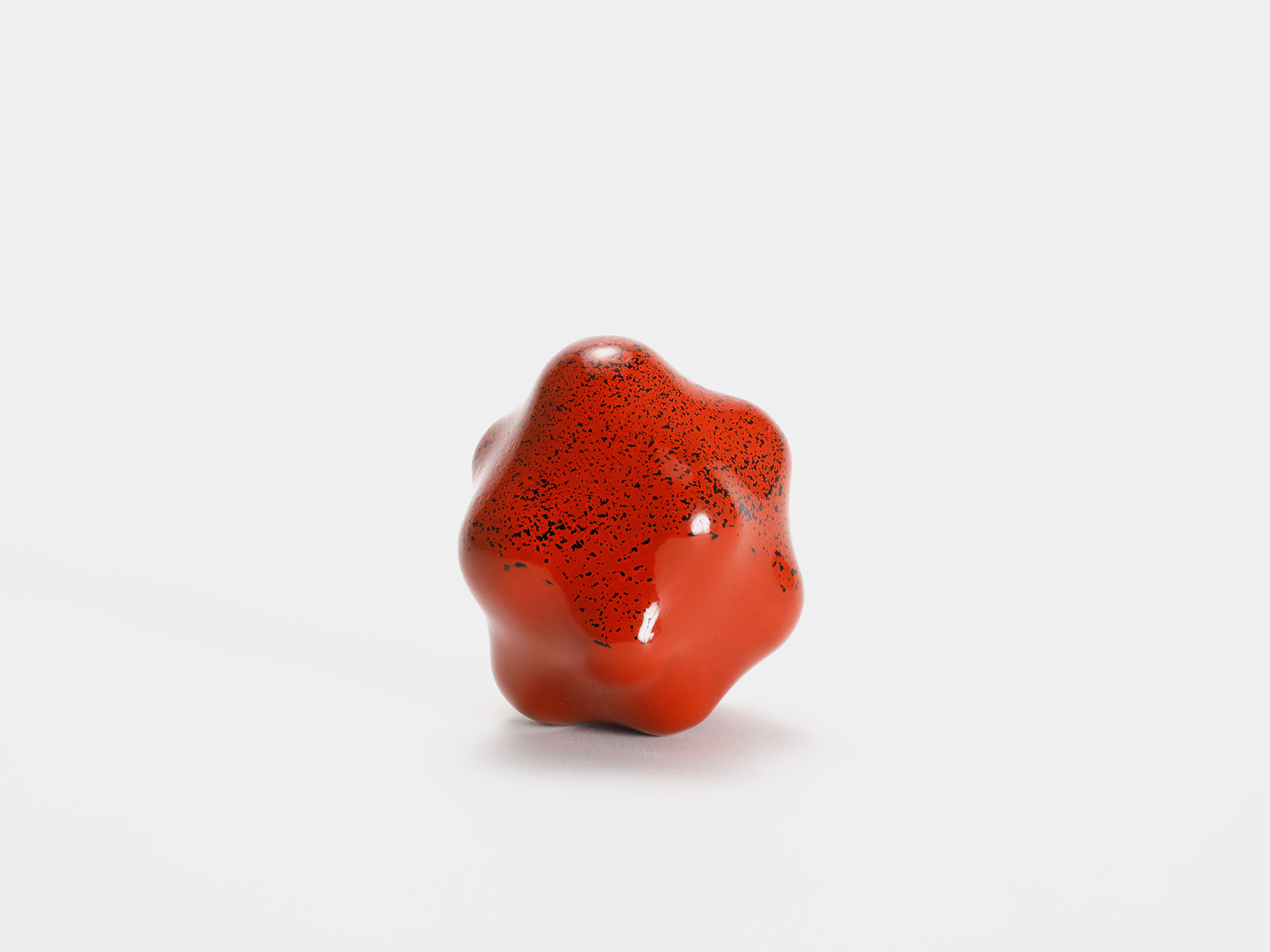 View of Untitled (Powder) by Genta Ishizuka, an organic red lacquer sculpture with a smooth matte...