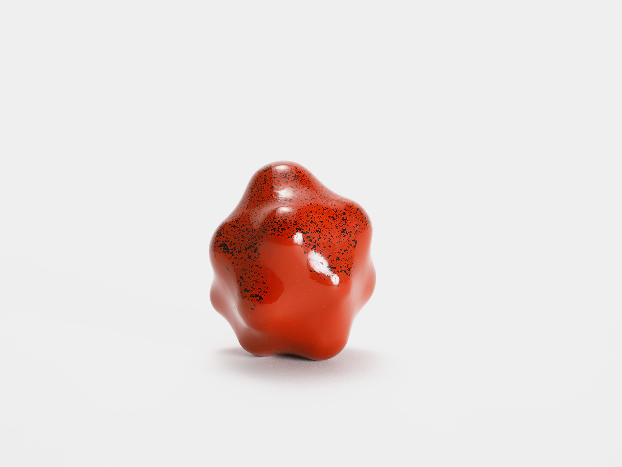 View of Untitled (Powder) by Genta Ishizuka, an organic red lacquer sculpture with a smooth matte...