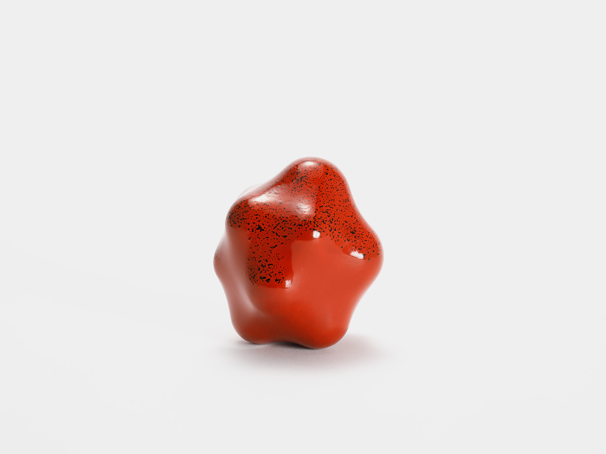 View of Untitled (Powder) by Genta Ishizuka, an organic red lacquer sculpture with a smooth matte...