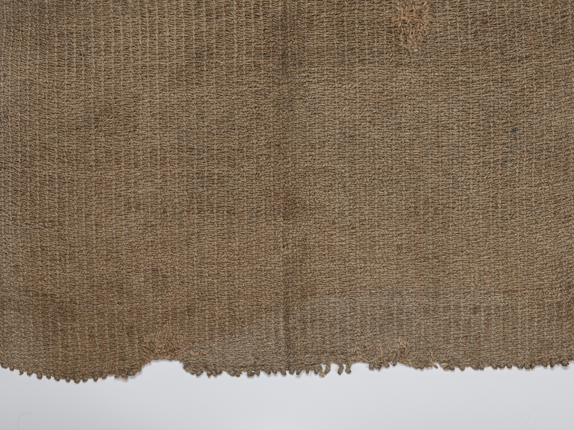 Detail of the lower edge of the angin maekake, showing the coarse bast fibers, open interlaced...