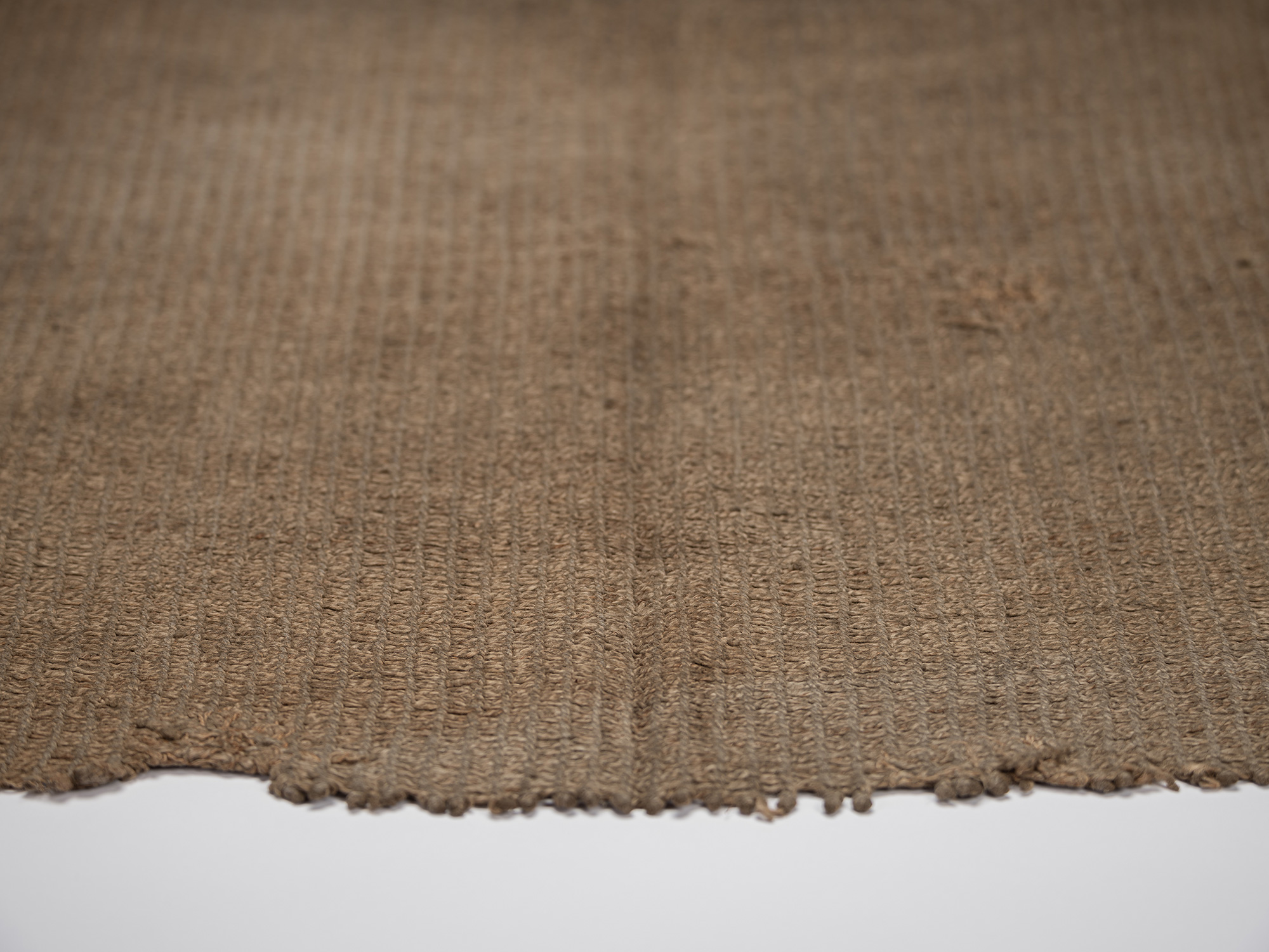 Detail of the lower edge of the angin maekake, showing the coarse bast fibers, open interlaced...