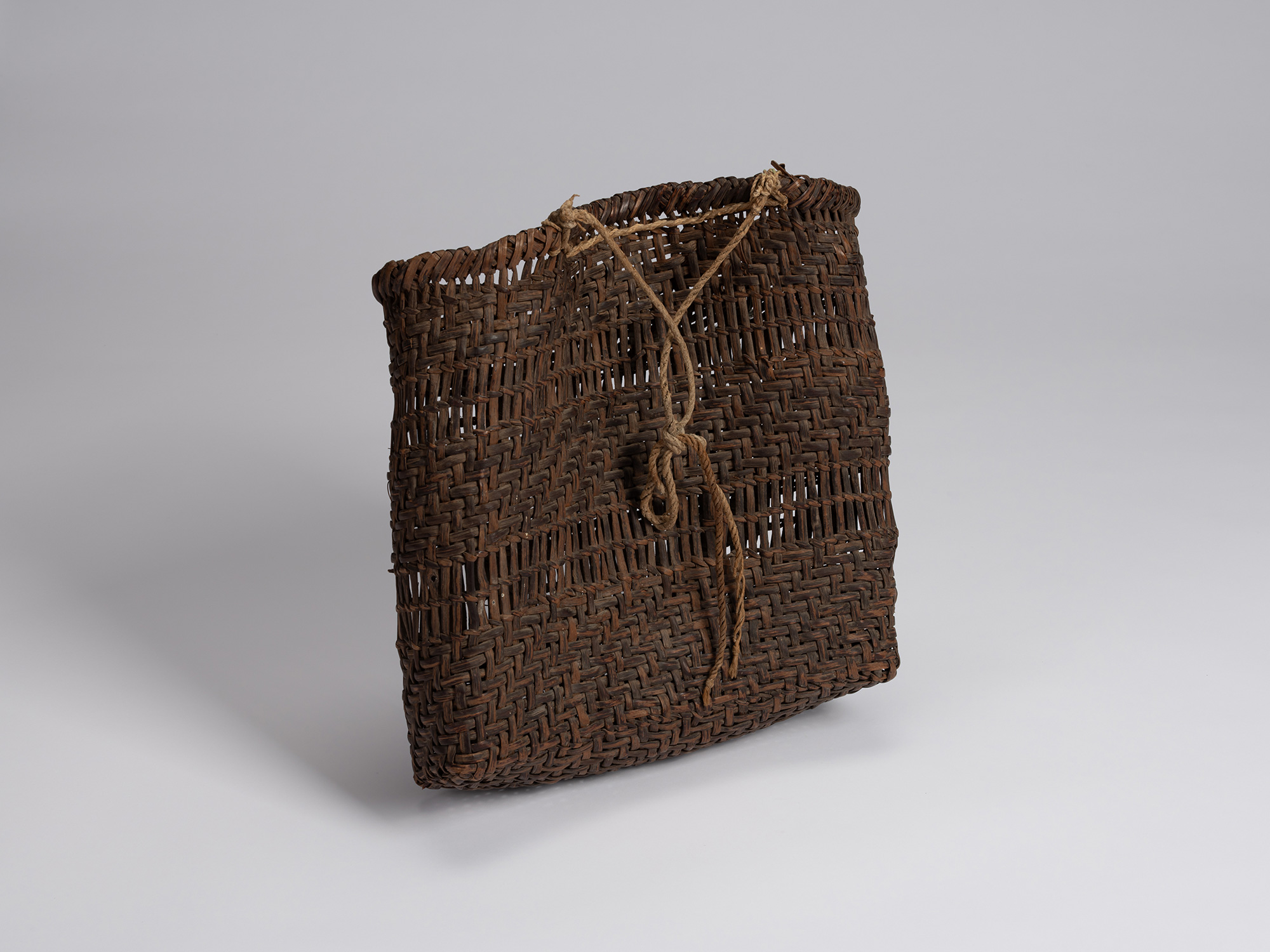 Rear three-quarter view of the wild mountain grape bark basket, showing alternating bands of dense...