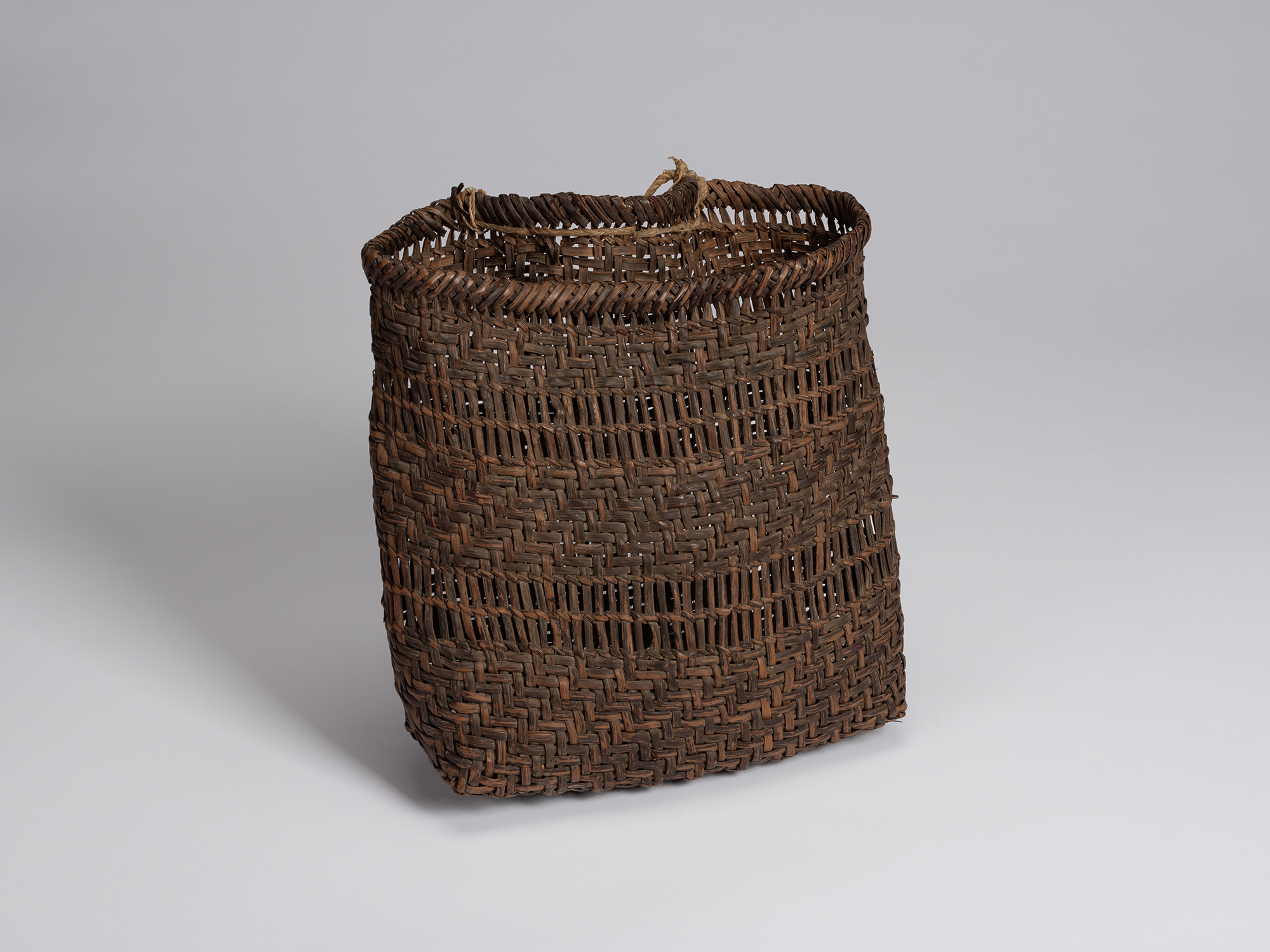 Three-quarter view of a rectangular basket woven from wild mountain grape bark, with alternating...