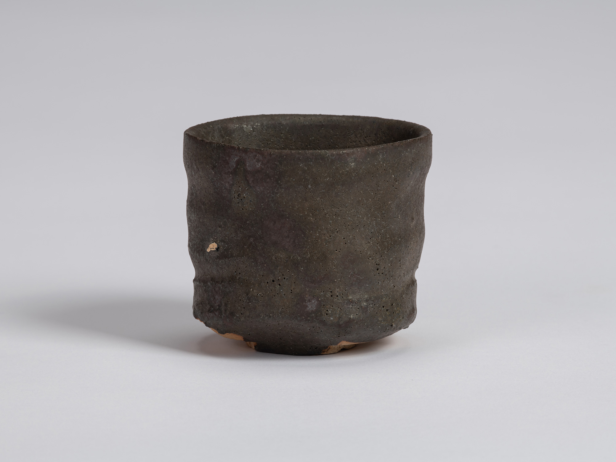 View of a Kuro Guinomi by Shiro Tsujimura, with a tall cylindrical form, subtly irregular rim,...