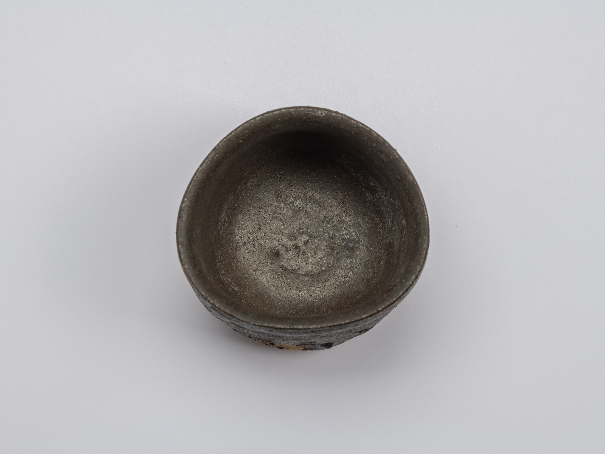 Overhead view of the Kuro Guinomi, showing the rounded rim and matte charcoal-black interior with...