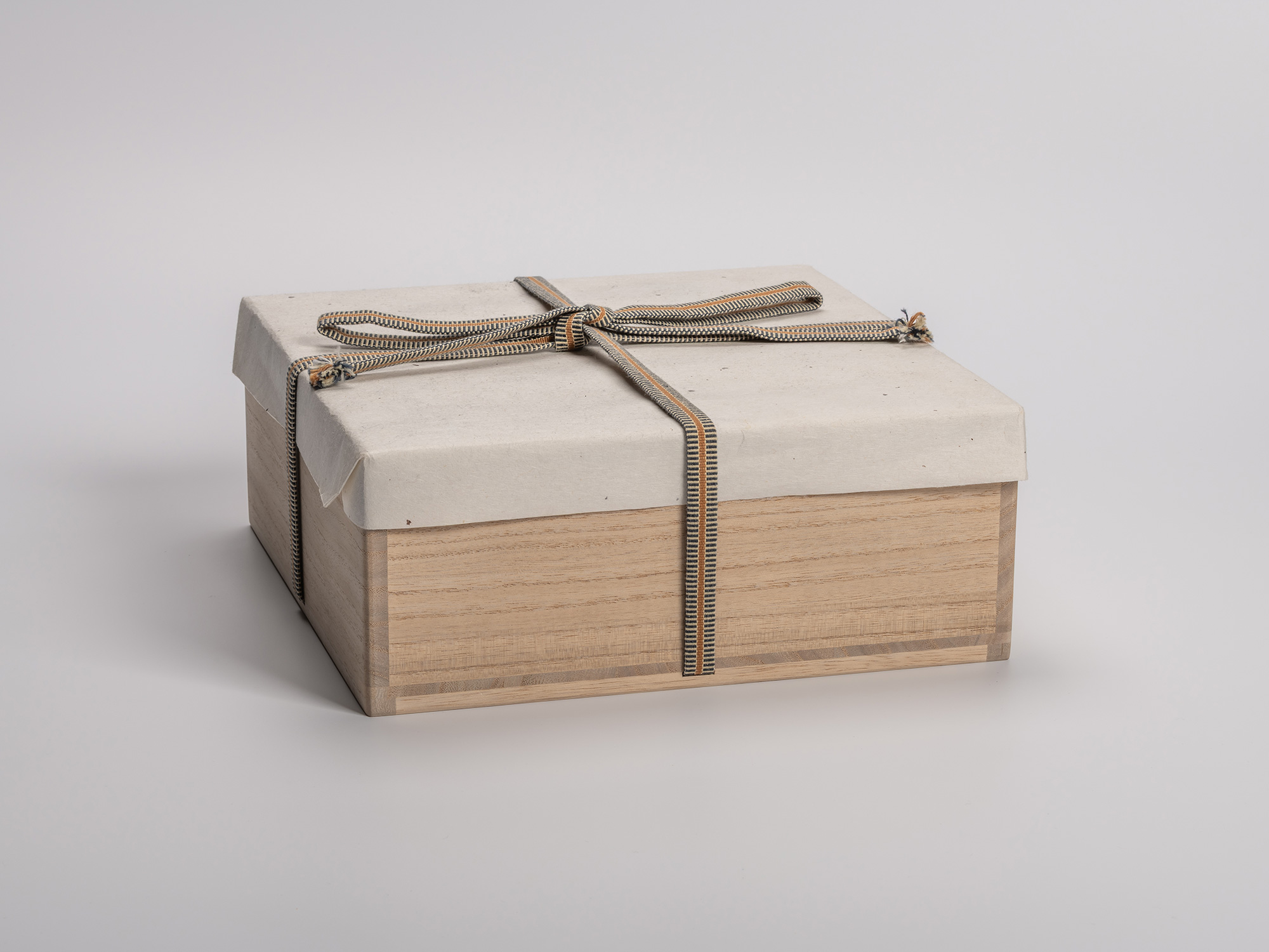 Large wooden tomobako designed to hold ten Kuro Guinomi by Shiro Tsujimura, wrapped in a protective...