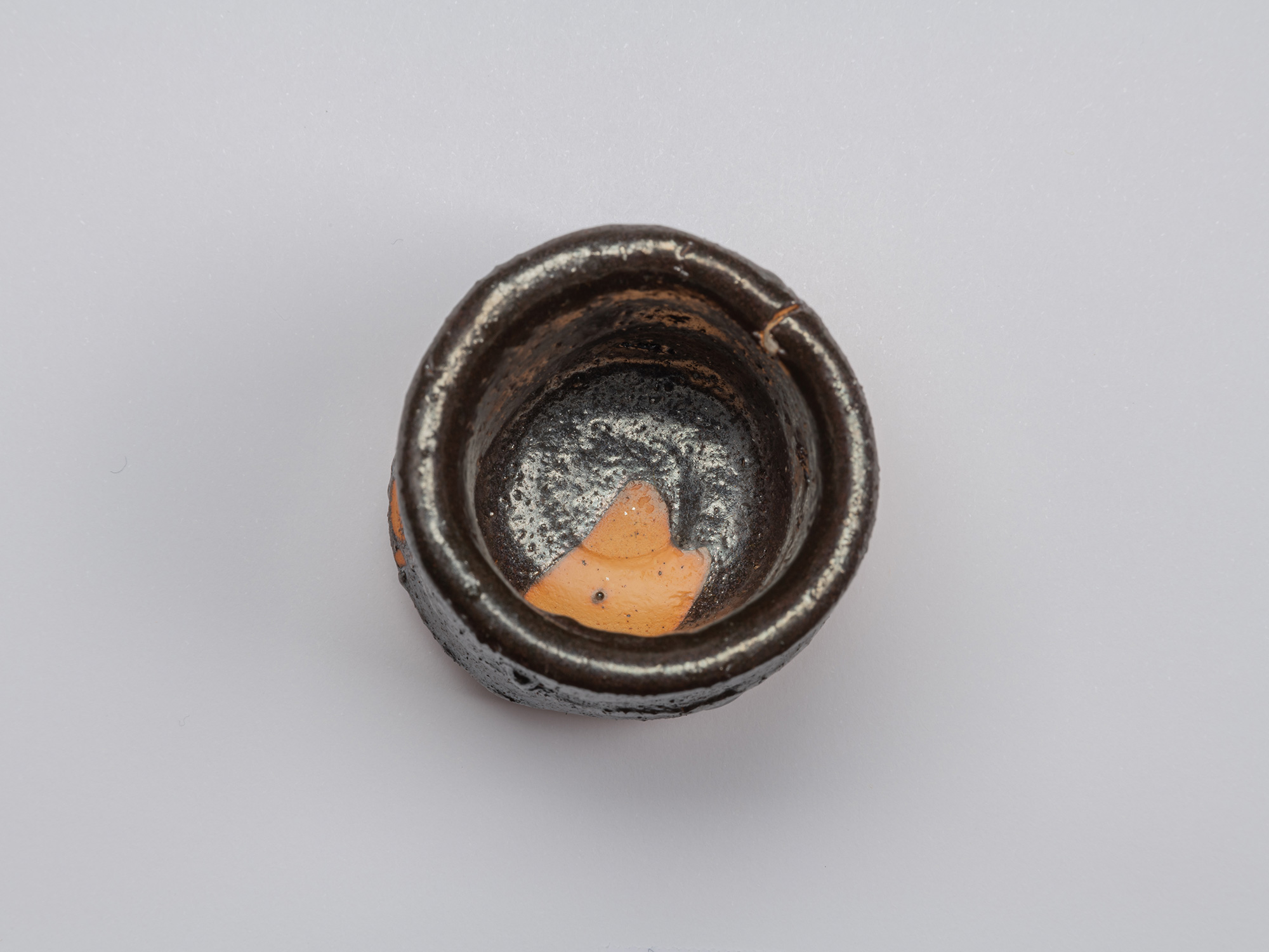 Top view of Kuro Guinomi by Shiro Tsujimura, showing a thick, irregular rim and glossy black interior...