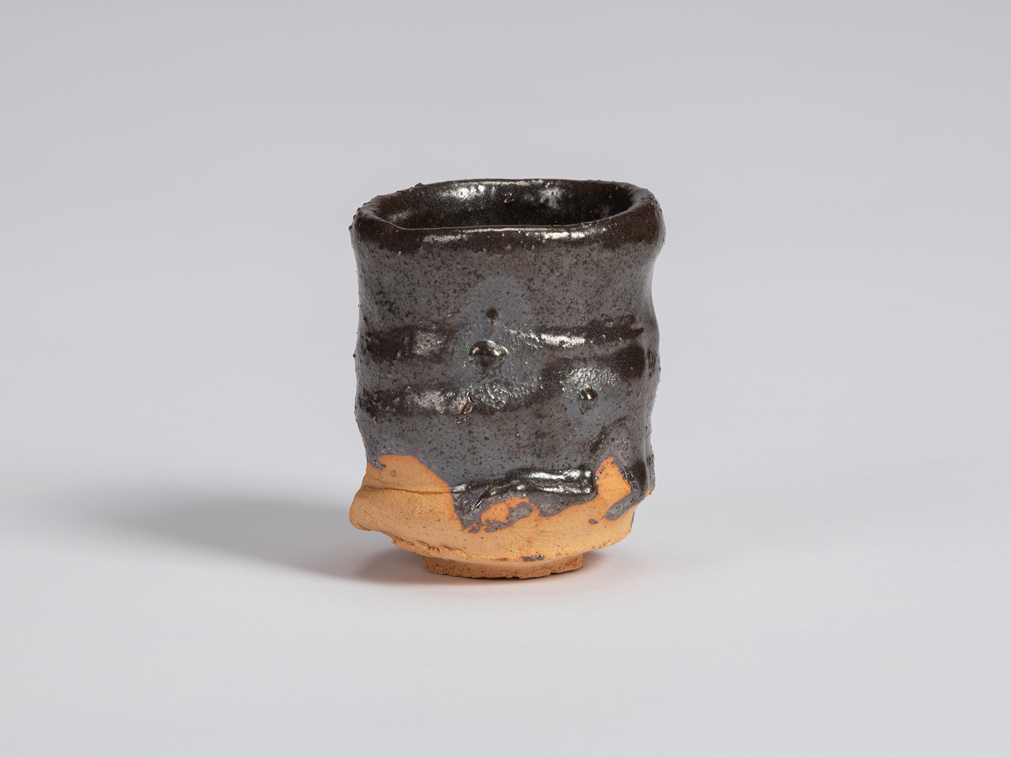 Kuro Guinomi by Shiro Tsujimura, with a slender cylindrical form, glossy black glaze, horizontal...