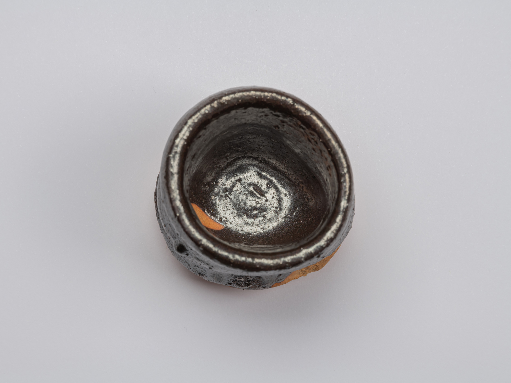 Aerial view of Kuro Guinomi by Shiro Tsujimura, showing a thick, irregular rim and glossy dark...