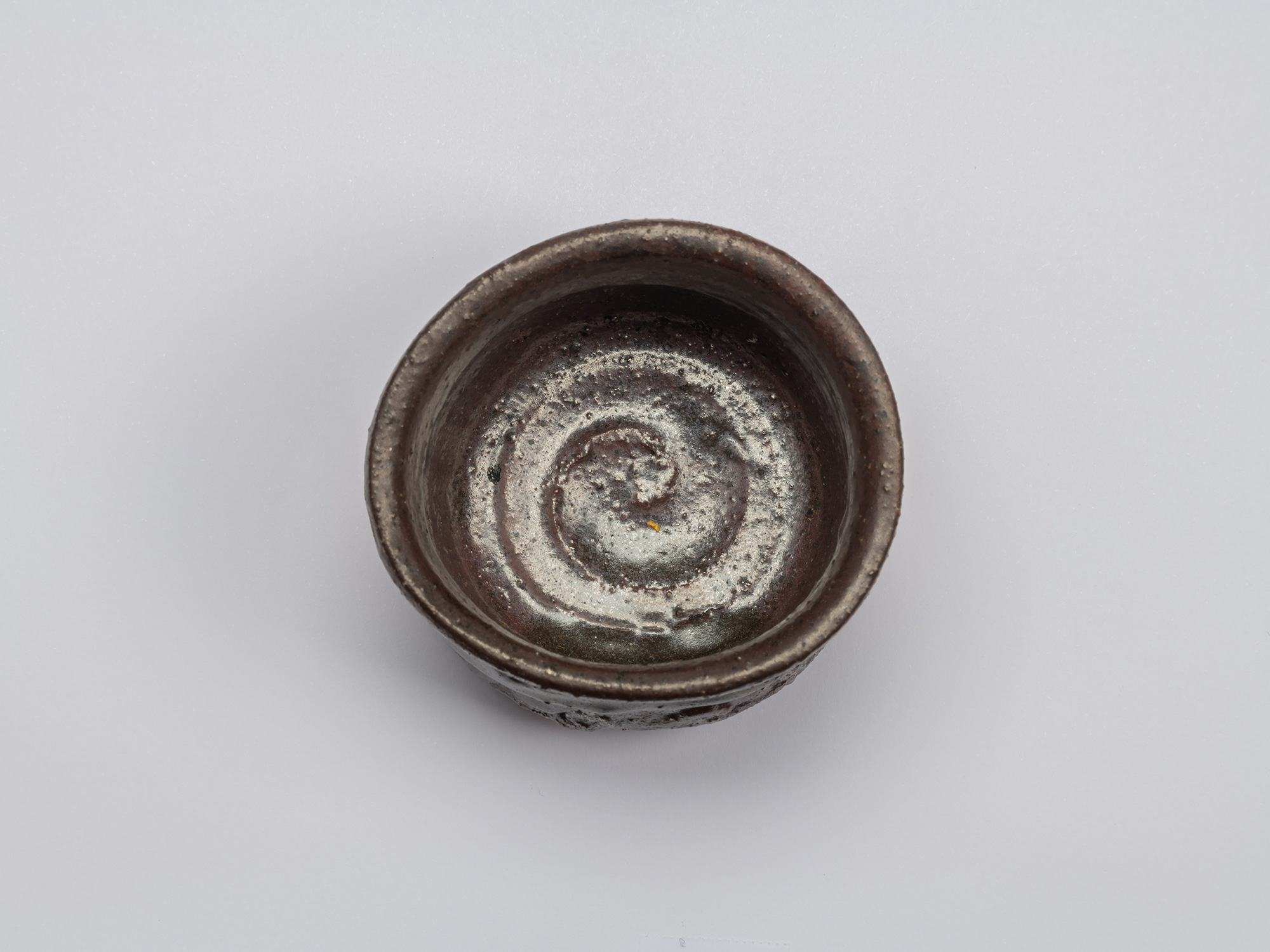 Interior view of Kuro Guinomi by Shiro Tsujimura, showing a dark brown-black glazed surface with...