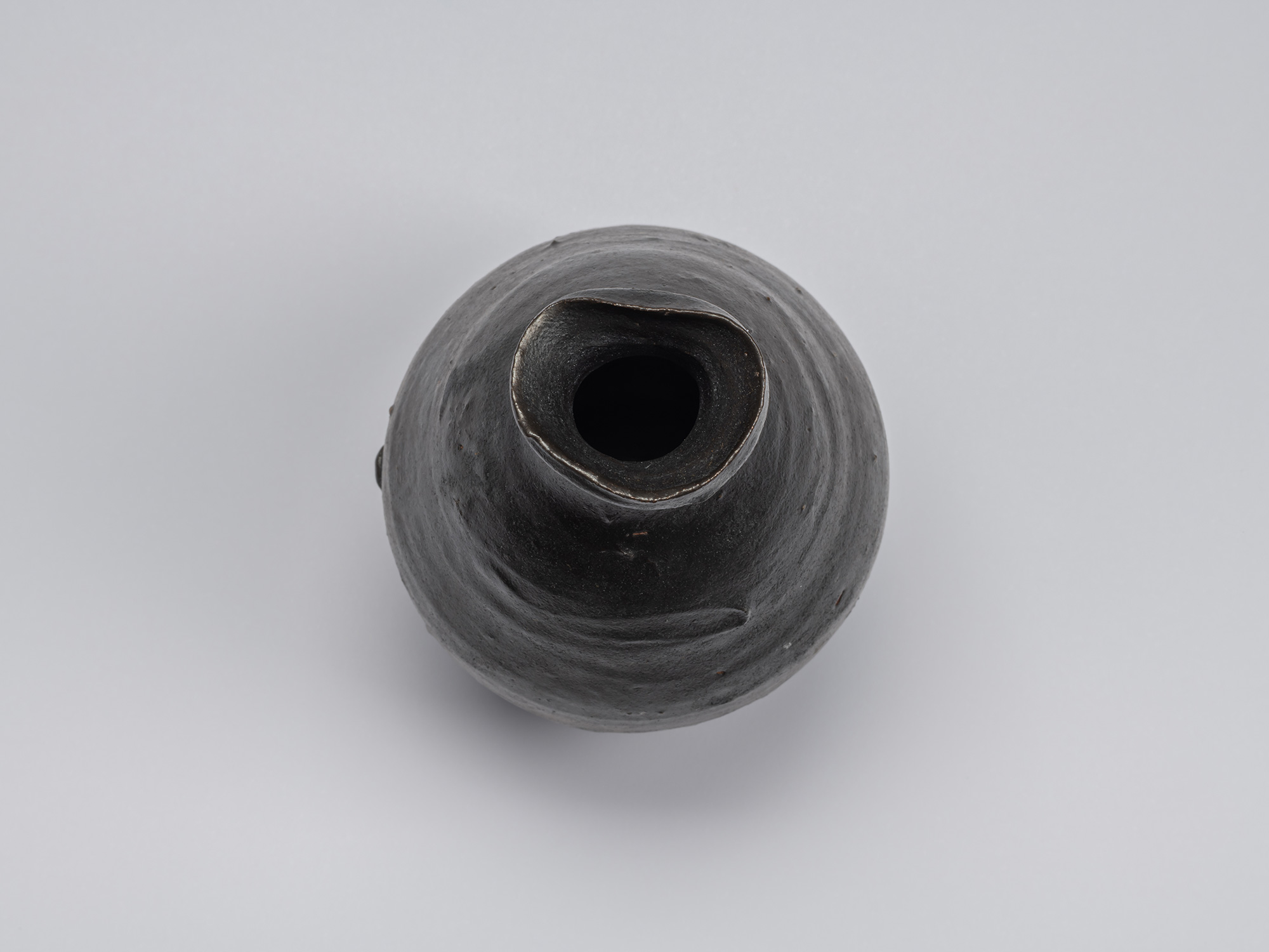 Overhead view of Shiro Tsujimura’s kuro tokkuri showing the rounded shoulders, narrow neck opening,...