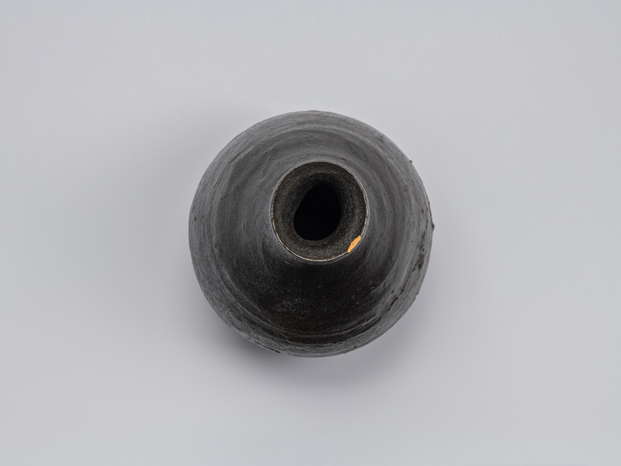 Overhead view of the Kuro Tokkuri by Shiro Tsujimura, showing the irregular oval mouth, uneven...