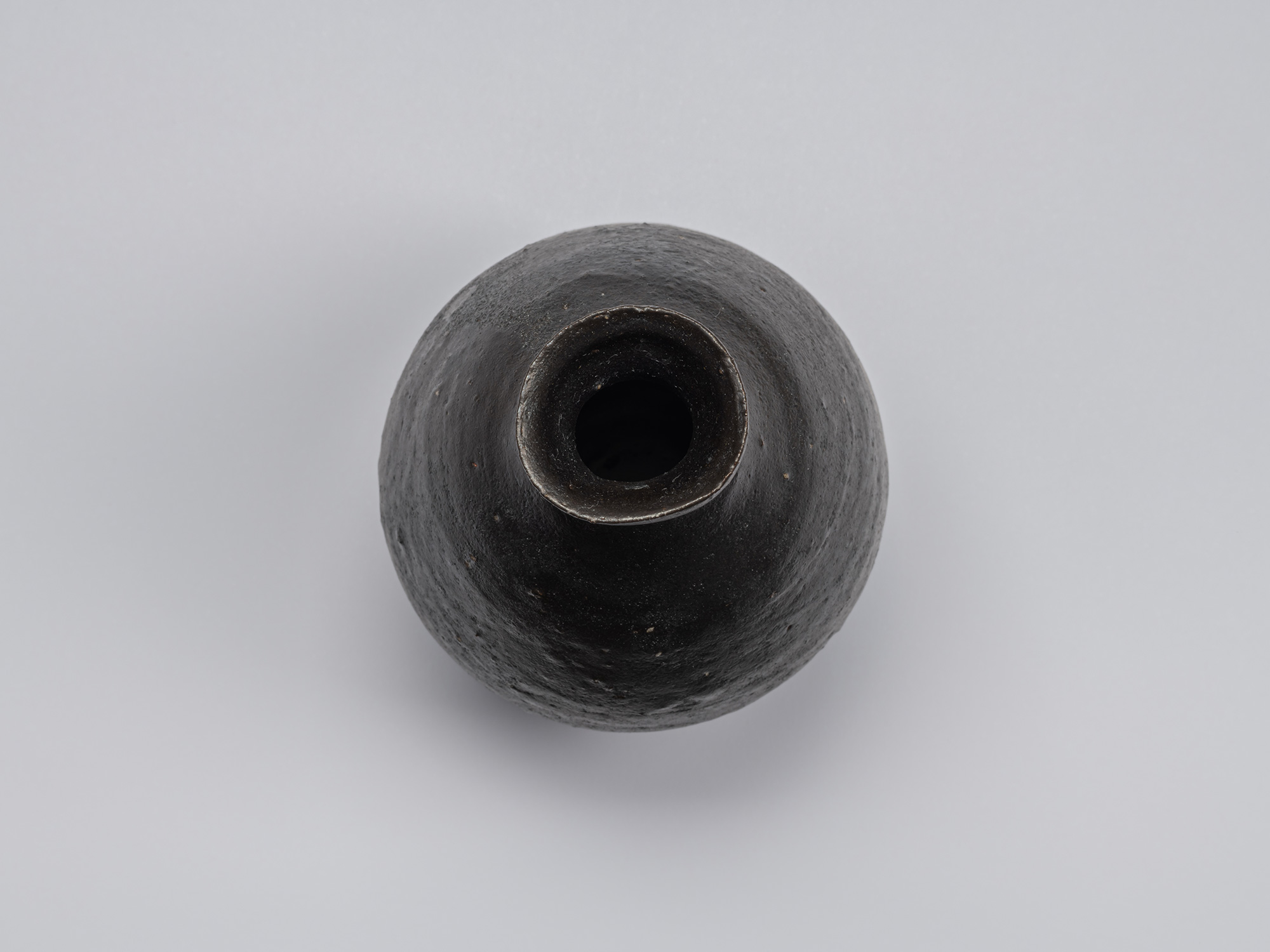Overhead view of Shiro Tsujimura’s kuro tokkuri showing its rounded shoulders, narrow neck opening,...