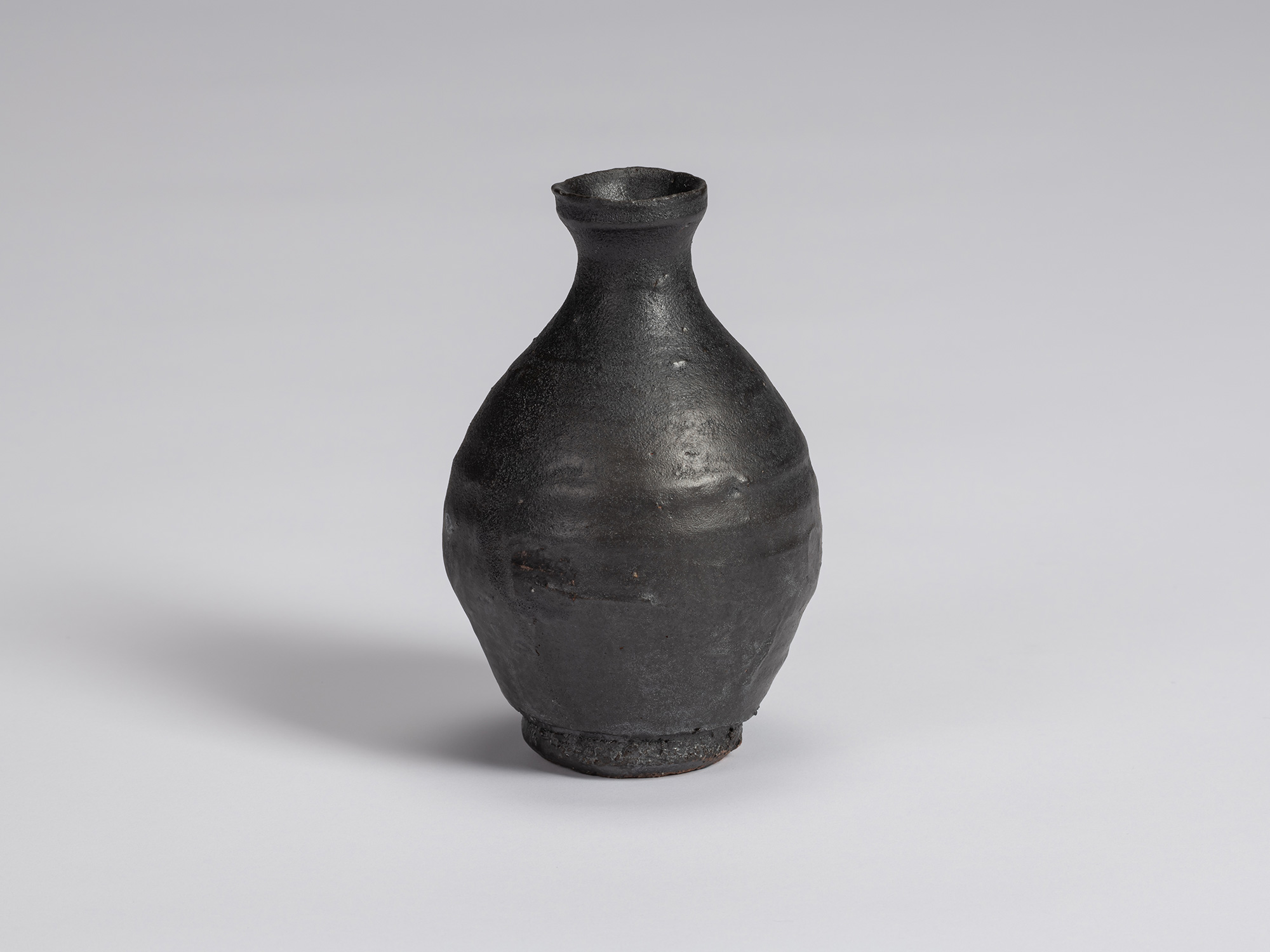 Kuro Tokkuri by Shiro Tsujimura with a tall, slightly asymmetrical pear-shaped body, narrow neck,...