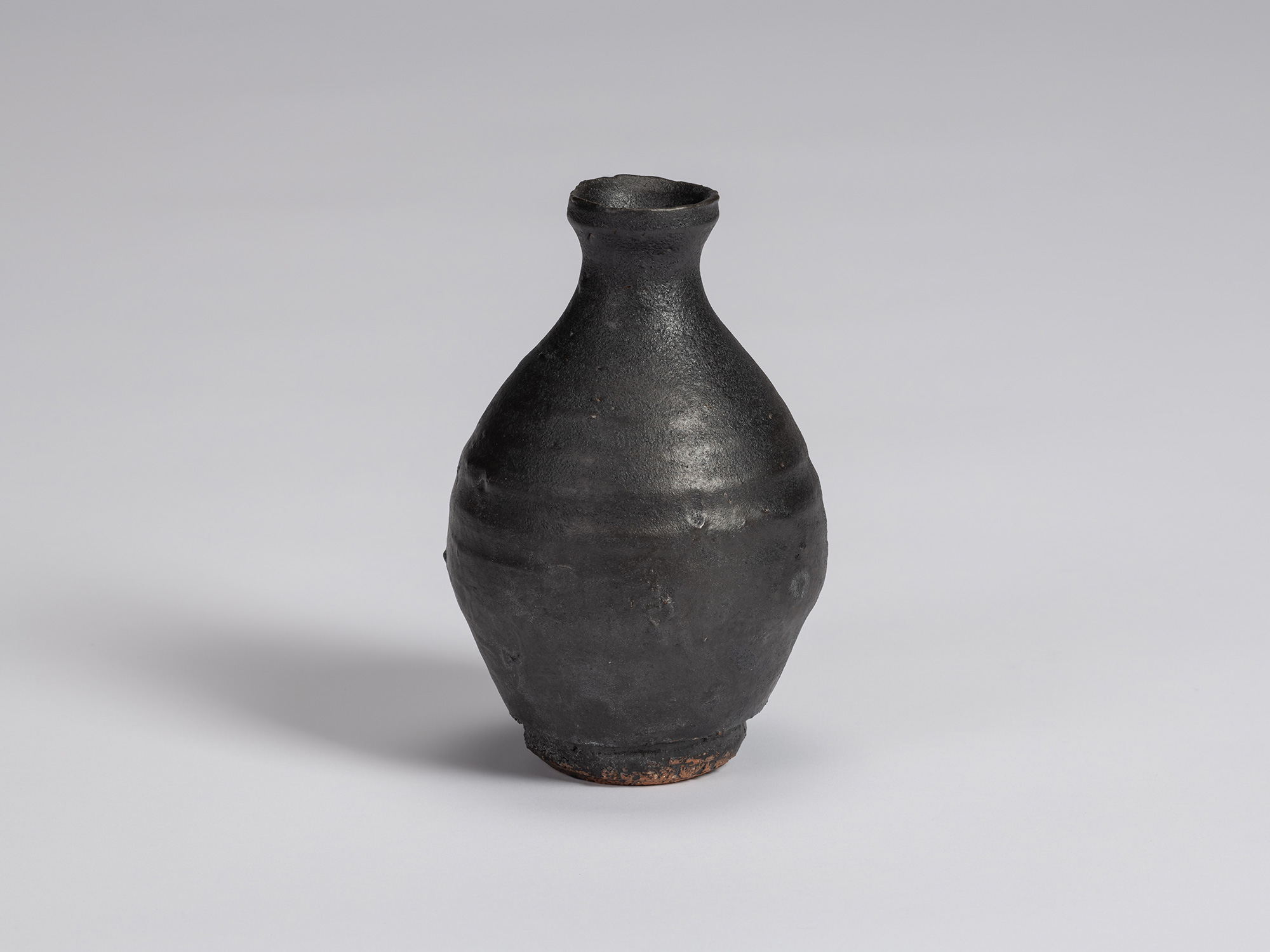 Kuro Tokkuri by Shiro Tsujimura with a tall, slightly asymmetrical pear-shaped body, narrow neck,...