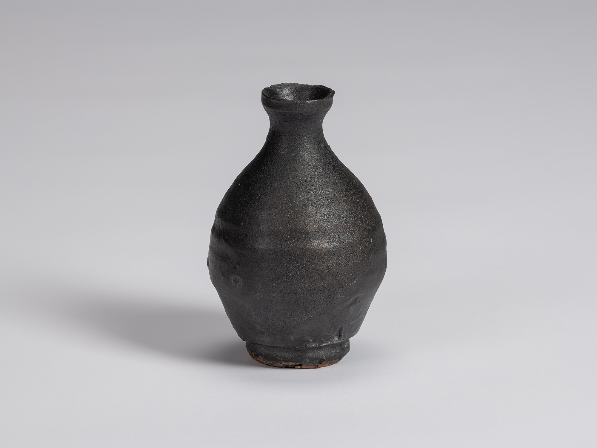 Kuro Tokkuri by Shiro Tsujimura with a tall, slightly asymmetrical pear-shaped body, narrow neck,...