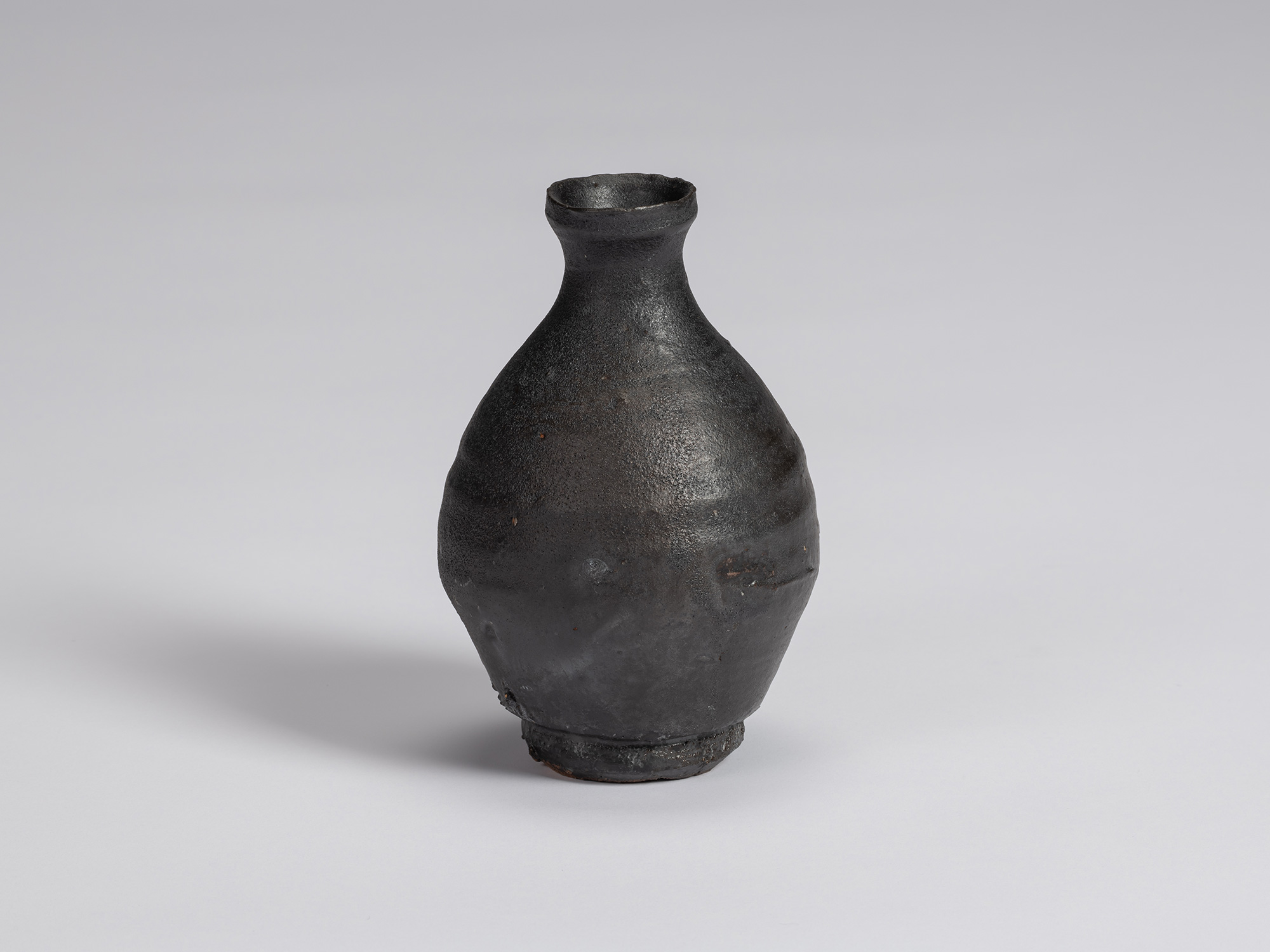 Kuro Tokkuri by Shiro Tsujimura with a tall, slightly asymmetrical pear-shaped body, narrow neck,...