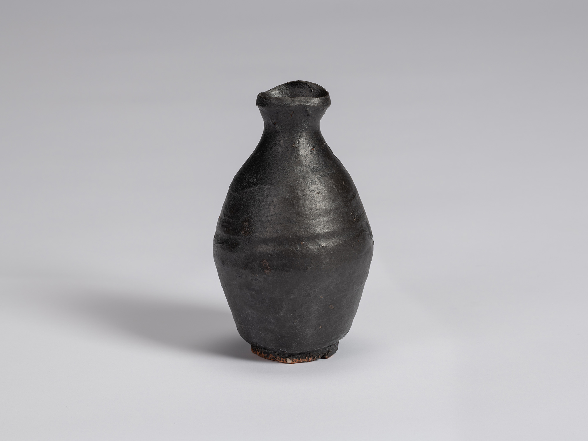 Kuro Tokkuri by Shiro Tsujimura with a tall, slightly asymmetrical body, tapered shoulders, narrow...
