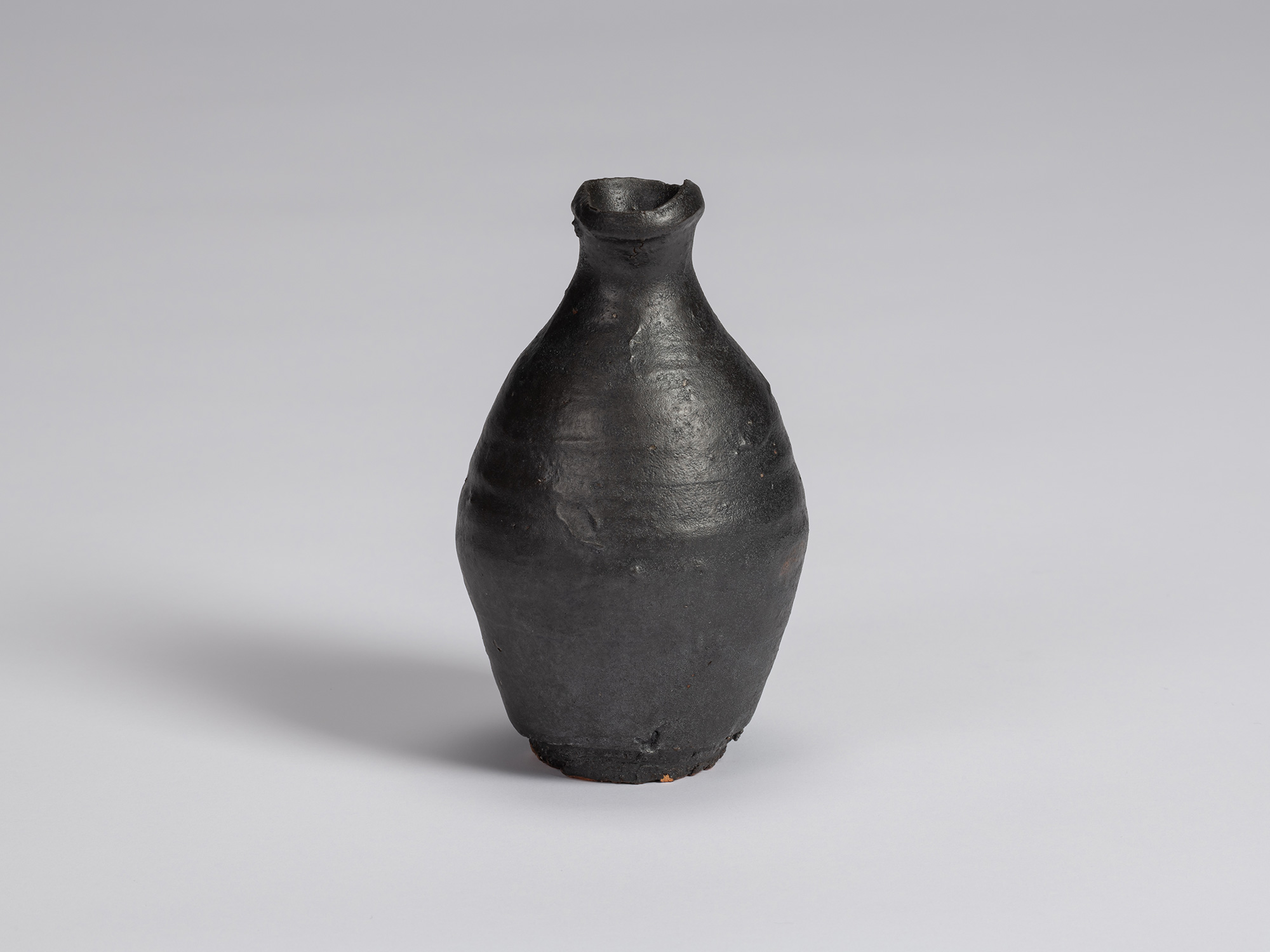 Kuro Tokkuri by Shiro Tsujimura with a tall, slightly asymmetrical body, tapered shoulders, narrow...