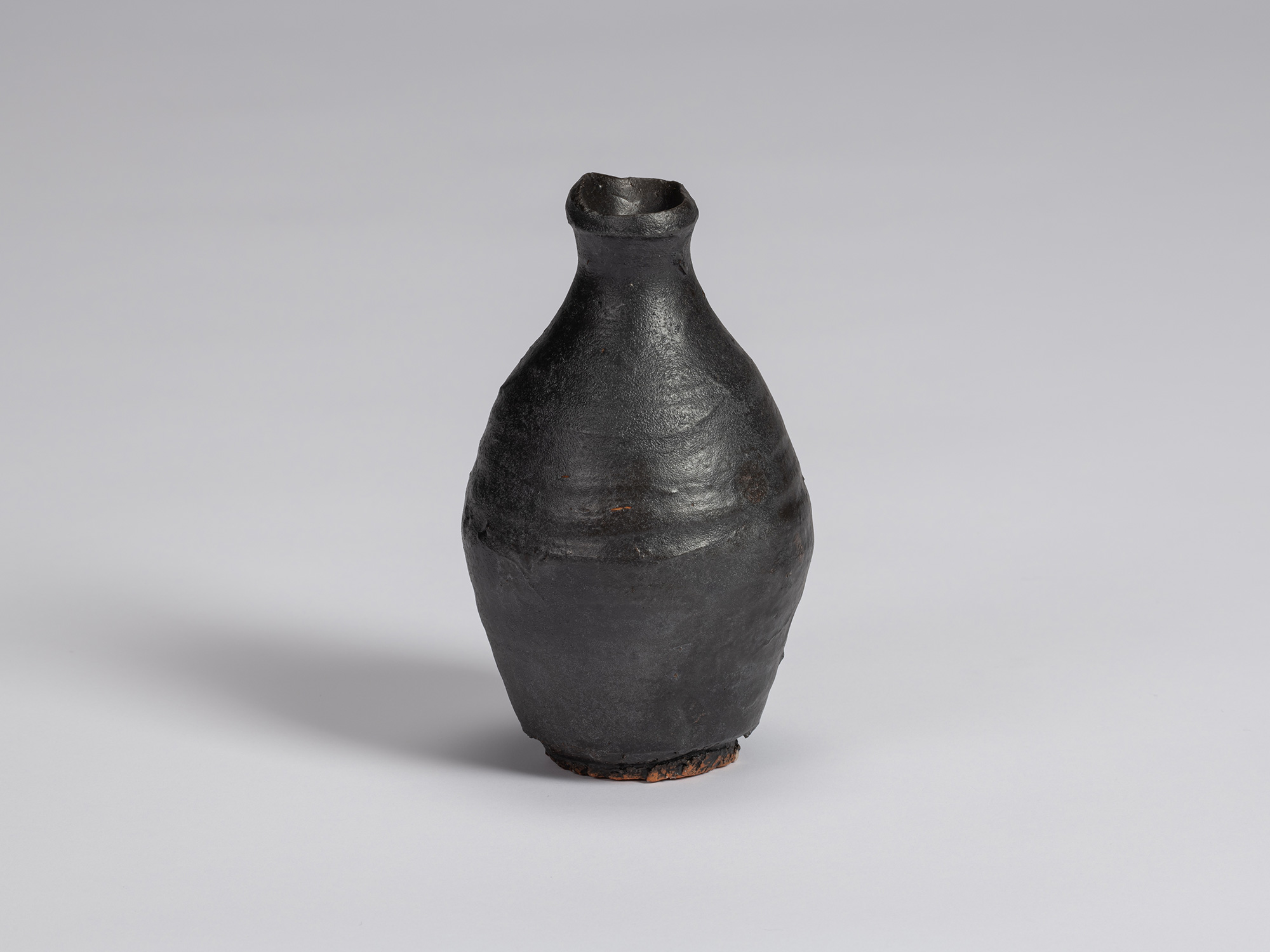 Kuro Tokkuri by Shiro Tsujimura with a tall, slightly asymmetrical body, tapered shoulders, narrow...