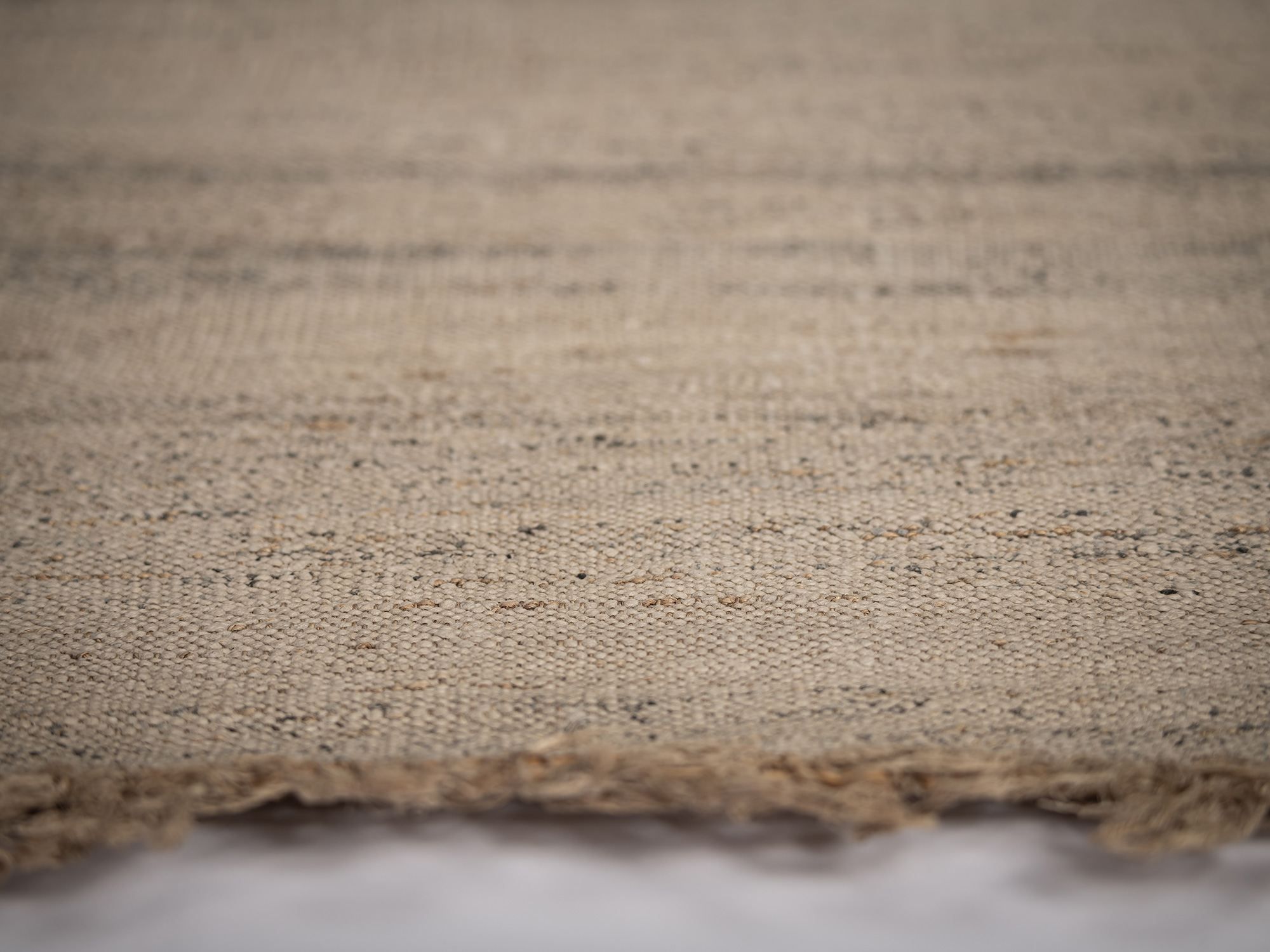Close-up of undyed otsuzure fabric showing the dense, irregular weave of wisteria and paper-wrapped...