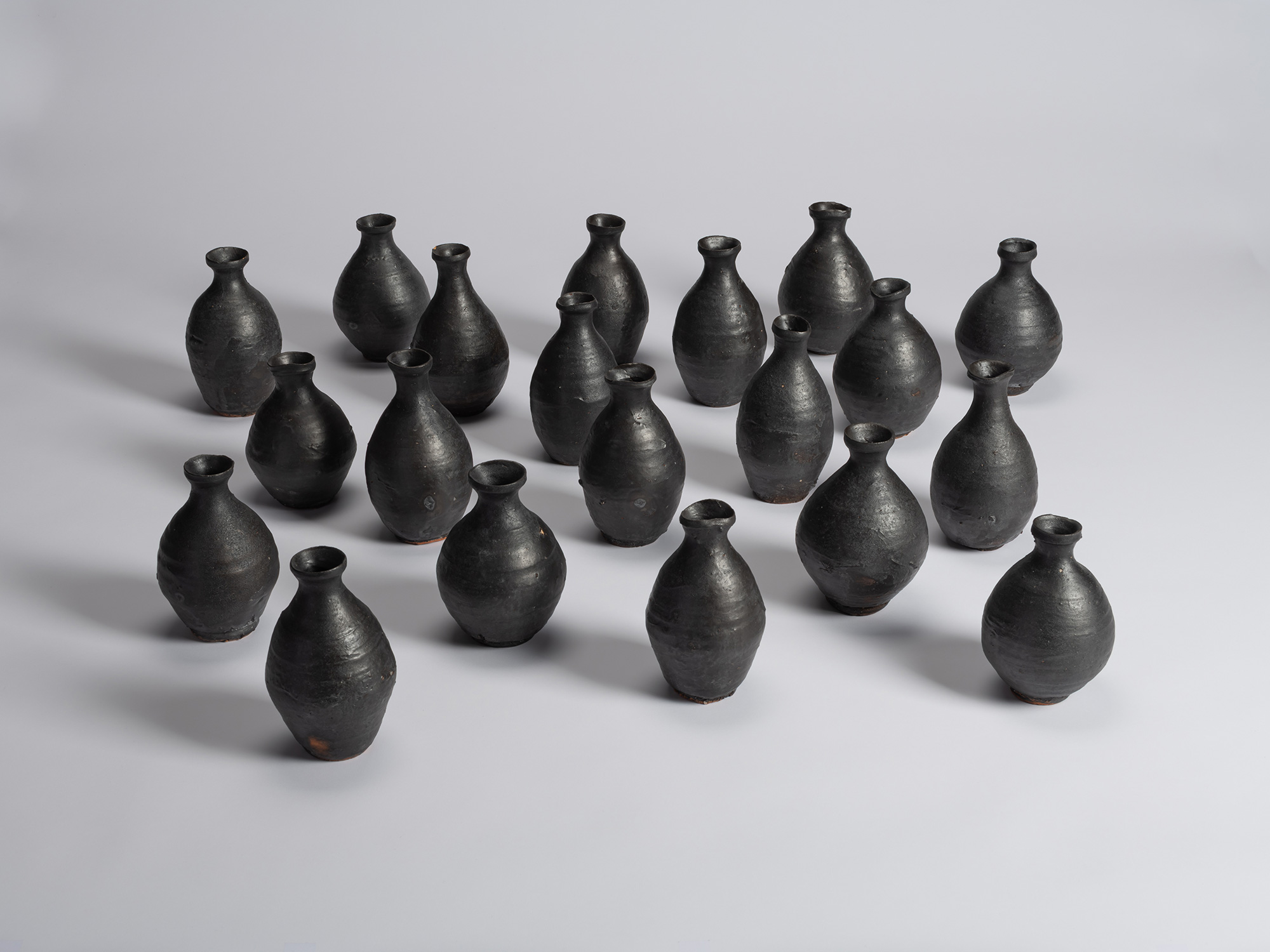 Group of twenty Kuro Tokkuri by Shiro Tsujimura, arranged together to show variations in their...