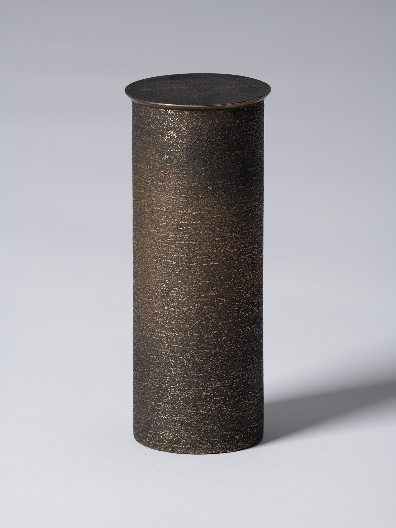 bronze as Bronze II No. 14 by Koji Hatakeyama, a tall cylindrical bronze vessel with a fitted circular...