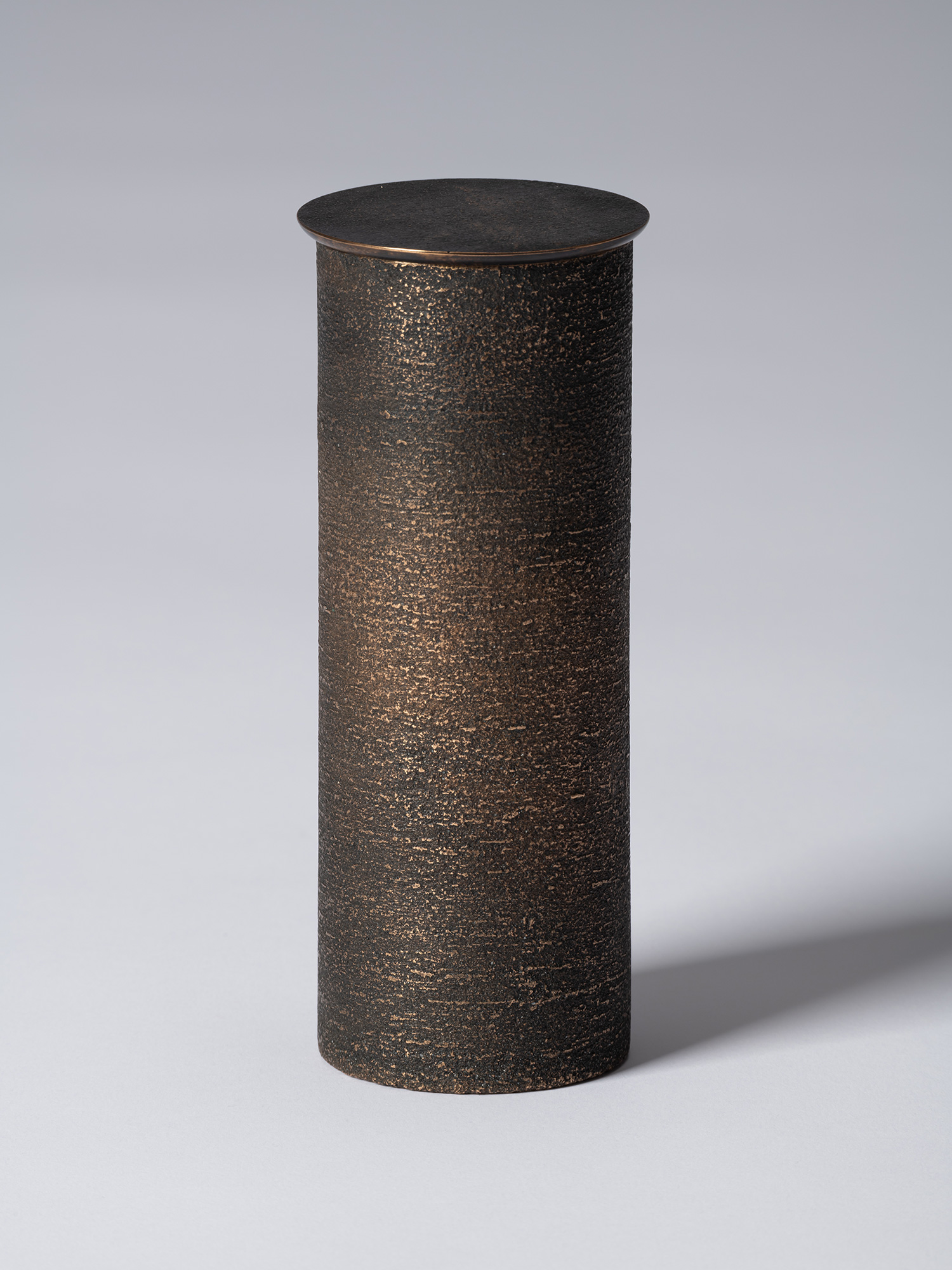 bronze as Bronze II No. 14 by Koji Hatakeyama, a tall cylindrical bronze vessel with a fitted circular...