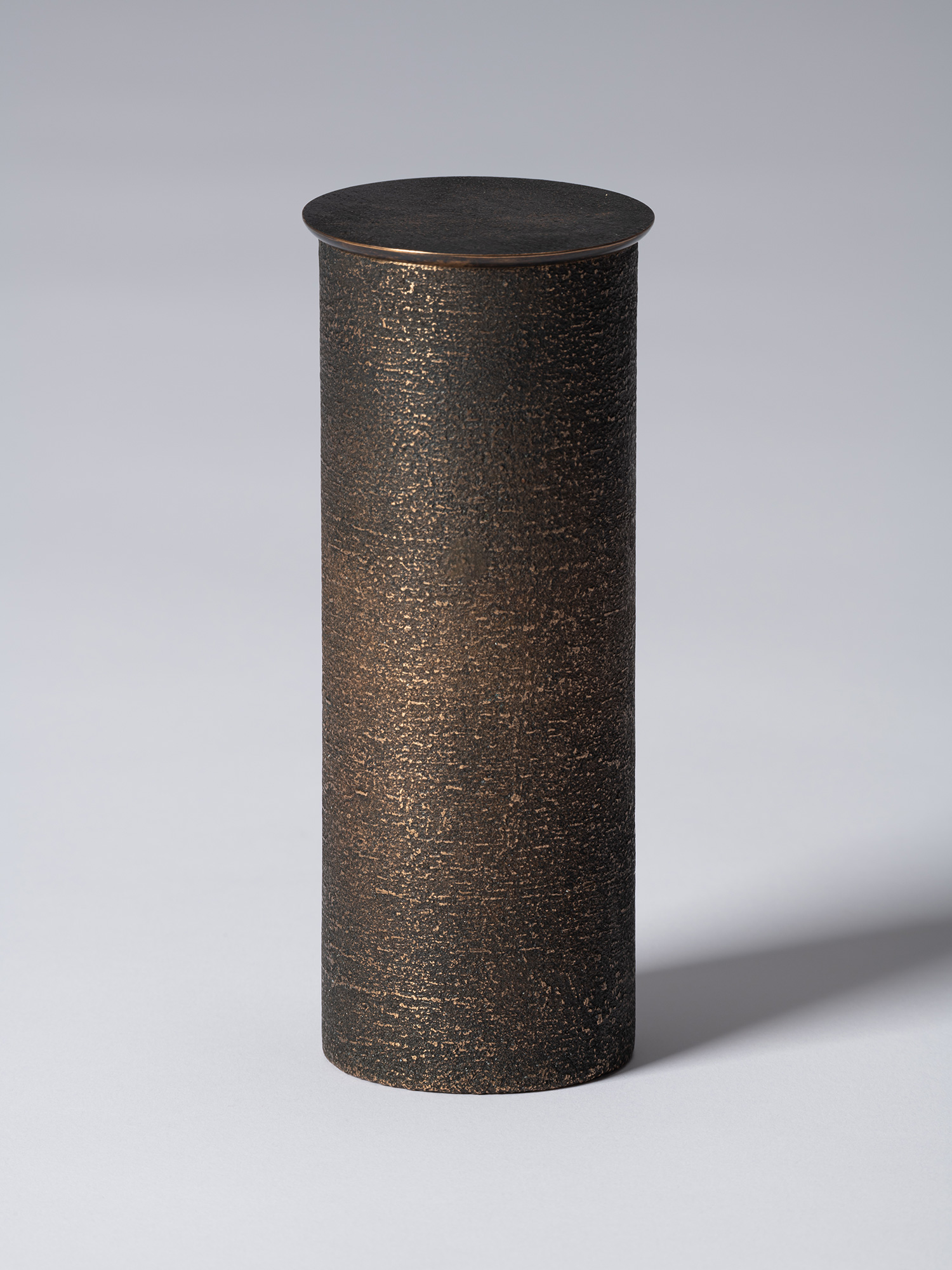 bronze as Bronze II No. 14 by Koji Hatakeyama, a tall cylindrical bronze vessel with a fitted circular...