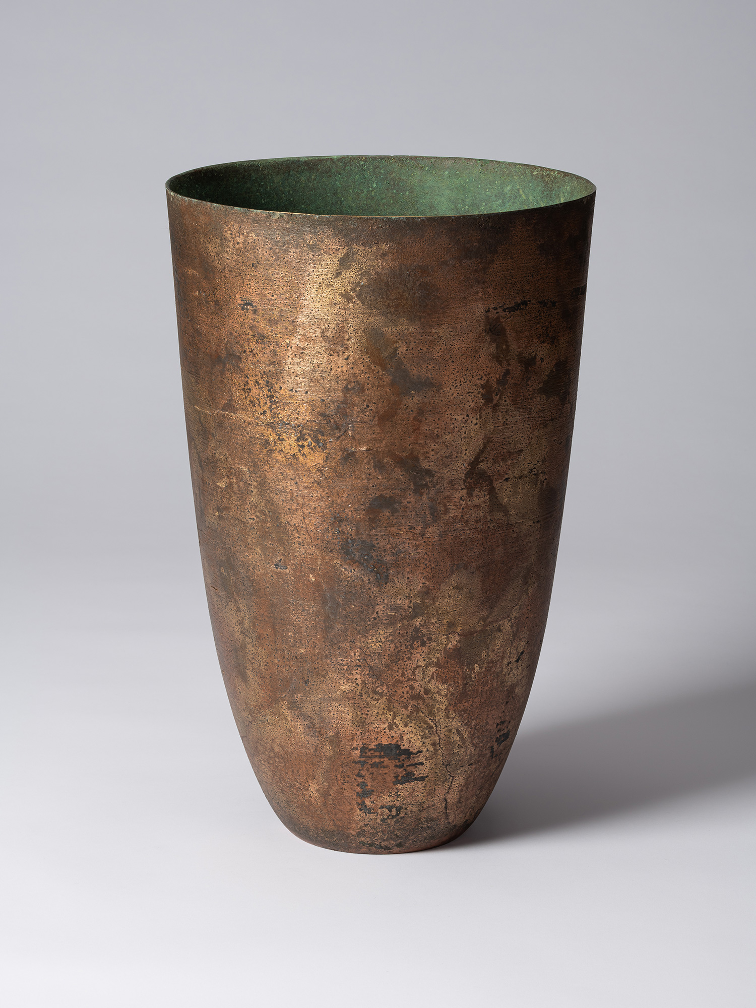 Front view of Koji Hatakeyama’s bronze as Bronze II No. 1, a tall, tapered bronze vessel with gently...