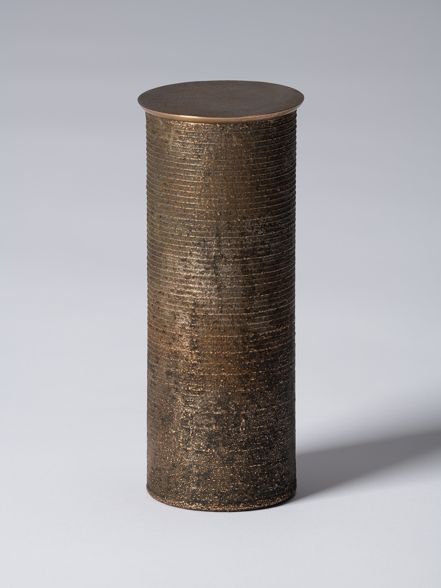 bronze as Bronze II No. 15 by Koji Hatakeyama, a tall cylindrical bronze vessel with a fitted circular...