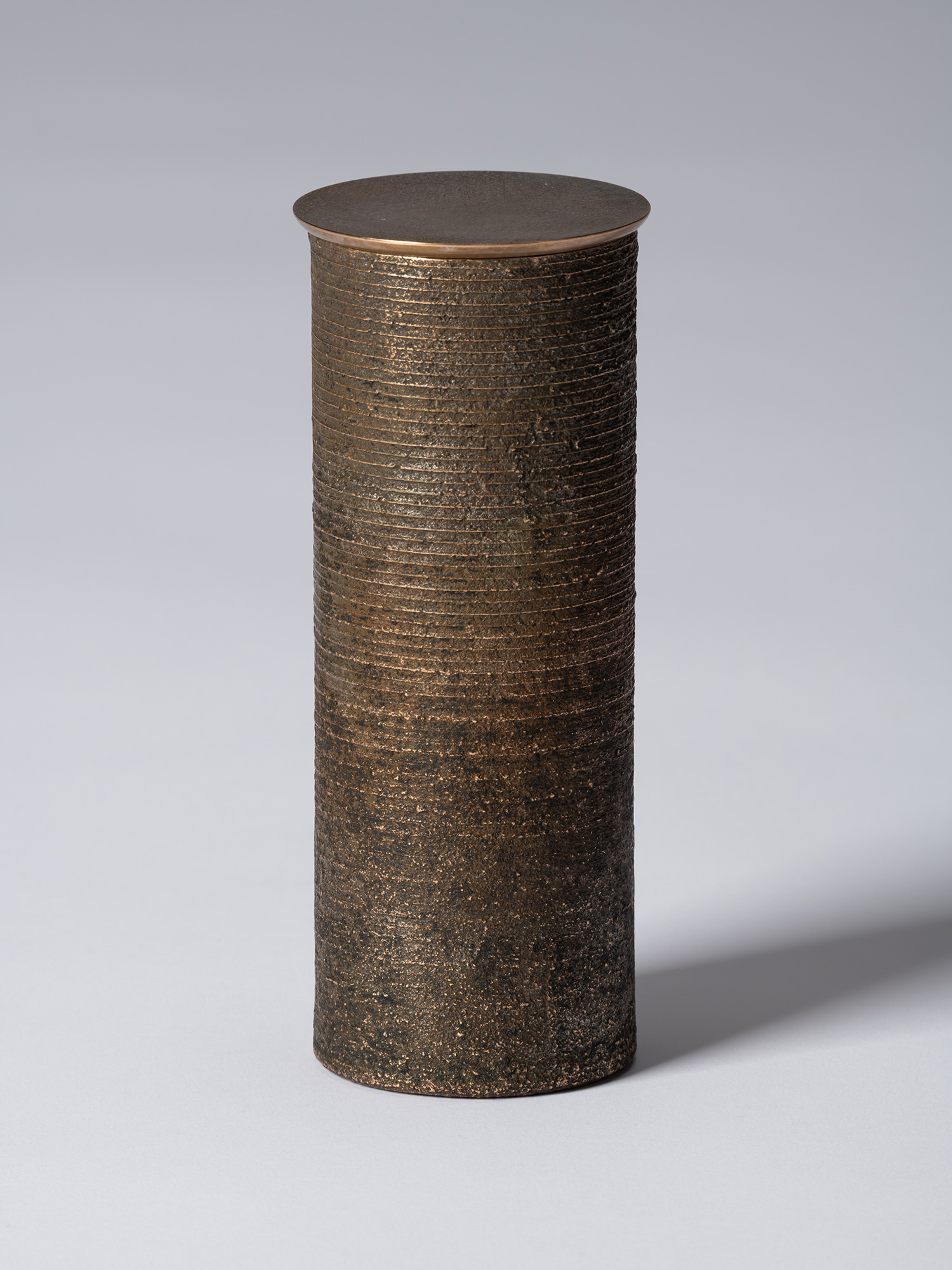 bronze as Bronze II No. 15 by Koji Hatakeyama, a tall cylindrical bronze vessel with a fitted circular...