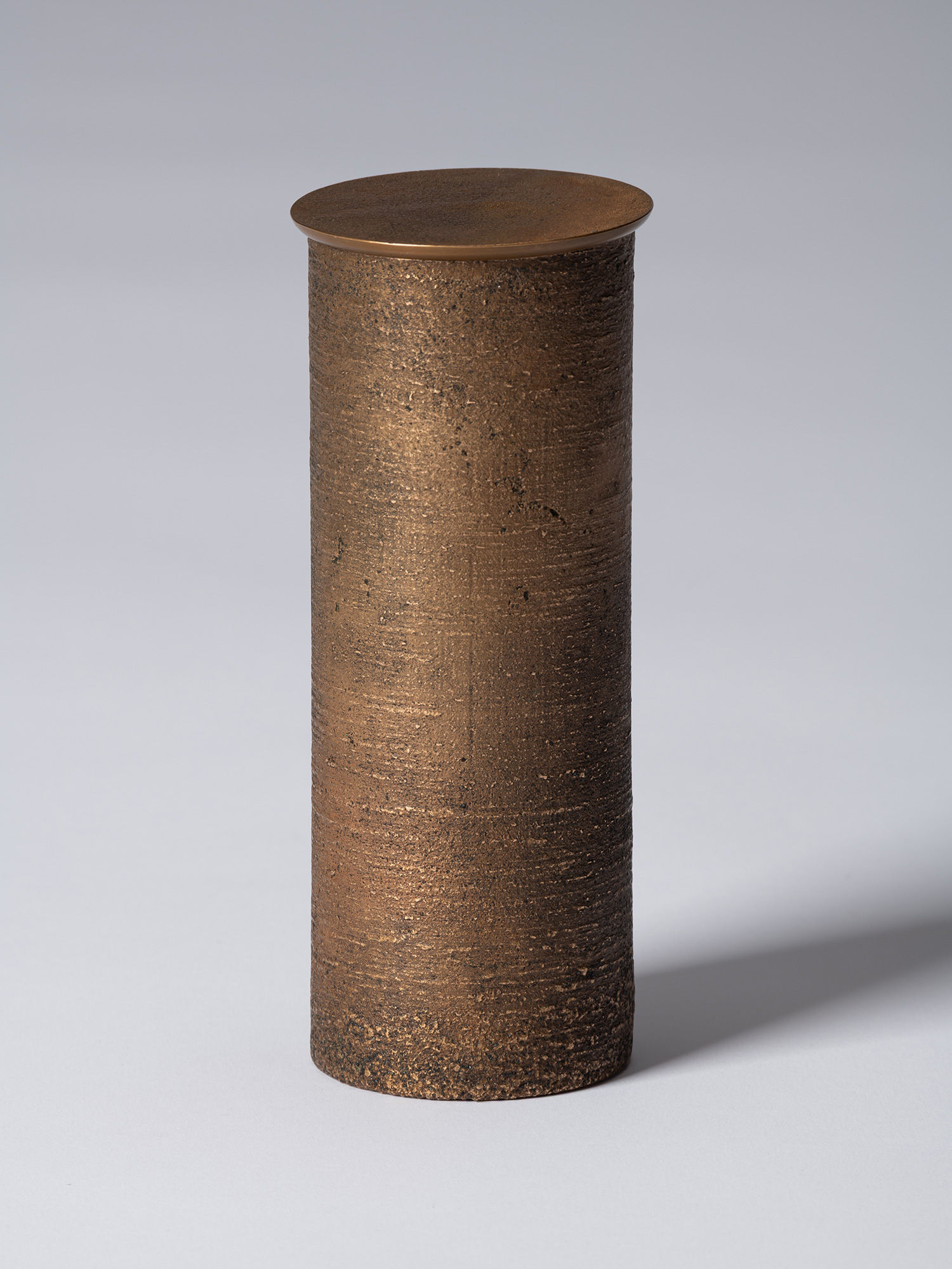 bronze as Bronze II No. 16 by Koji Hatakeyama, a tall cylindrical bronze vessel with a fitted circular...