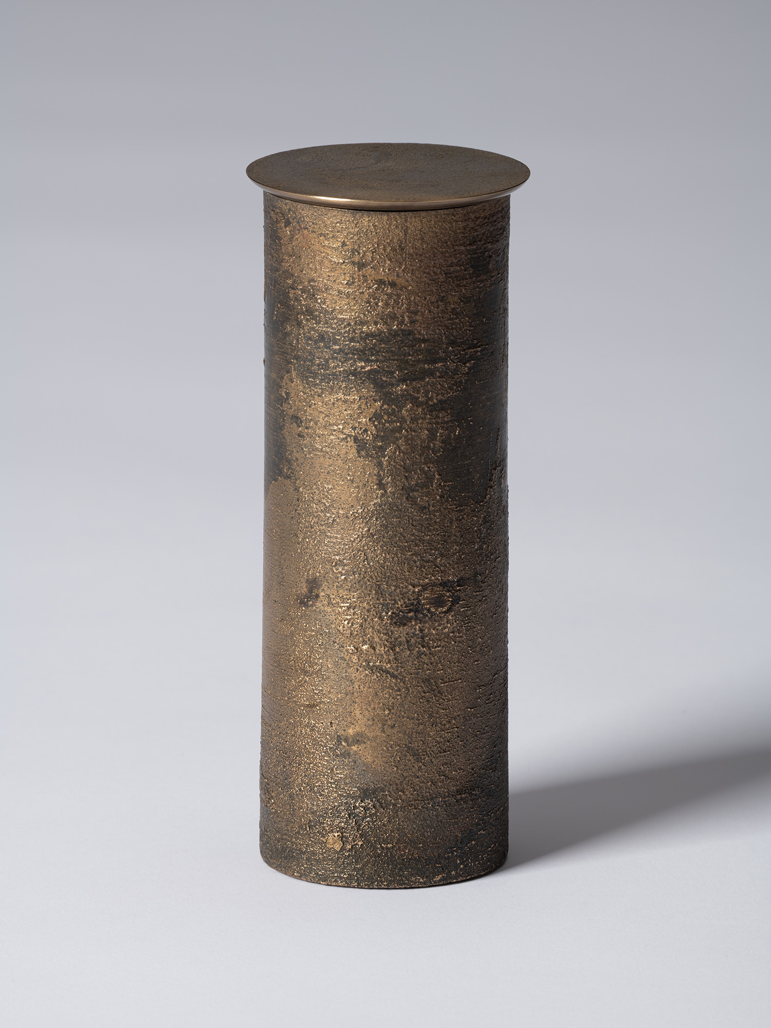 bronze as Bronze II No. 19 by Koji Hatakeyama, a tall cylindrical bronze vessel with a fitted circular...