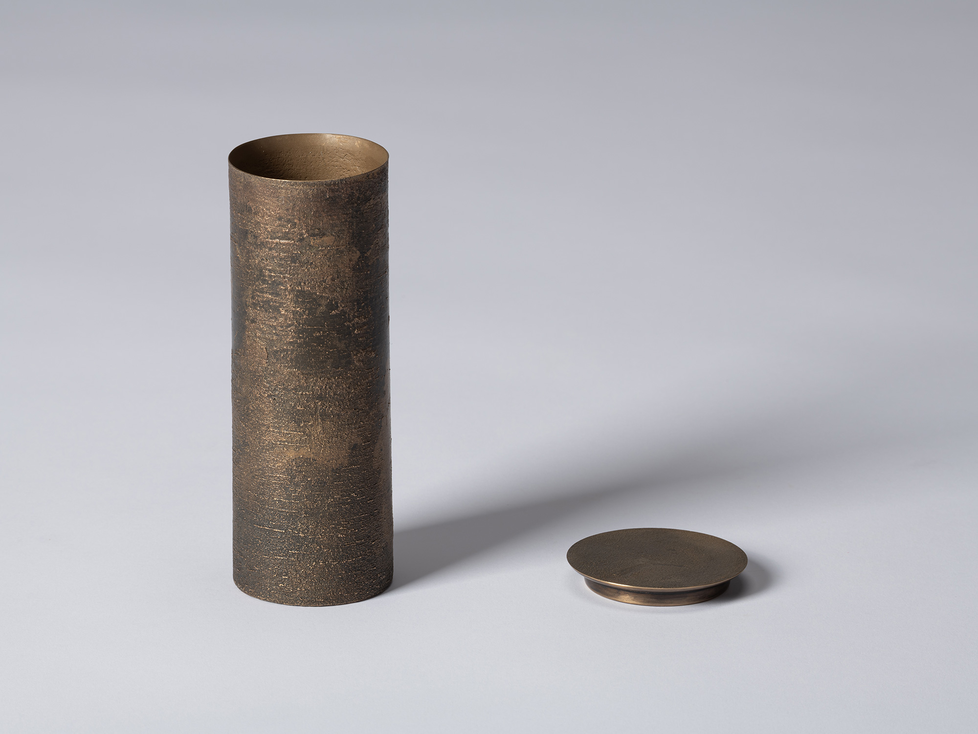 bronze as Bronze II No. 19 by Koji Hatakeyama with its circular lid removed, revealing the open...