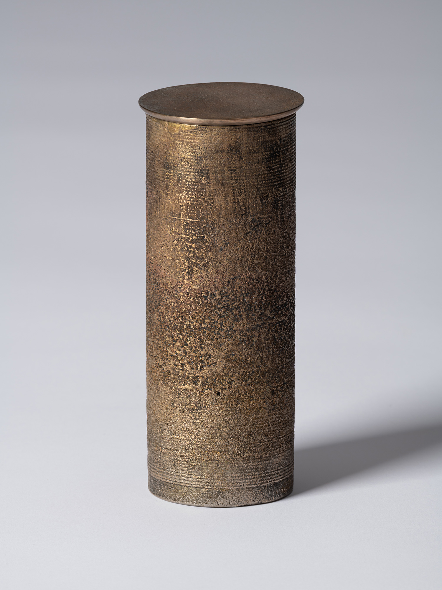bronze as Bronze II No. 20 by Koji Hatakeyama, a tall cylindrical bronze vessel with a fitted circular...