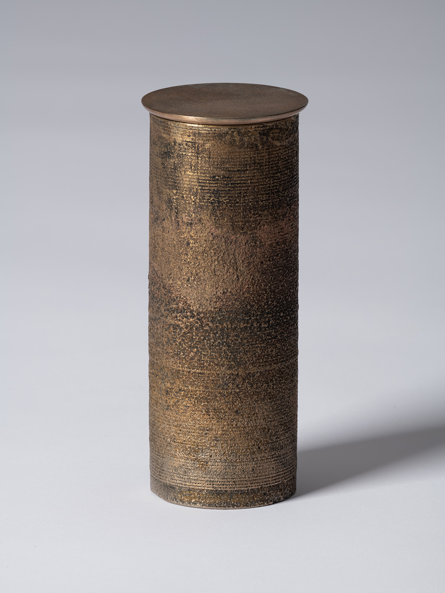 bronze as Bronze II No. 20 by Koji Hatakeyama, a tall cylindrical bronze vessel with a fitted circular...