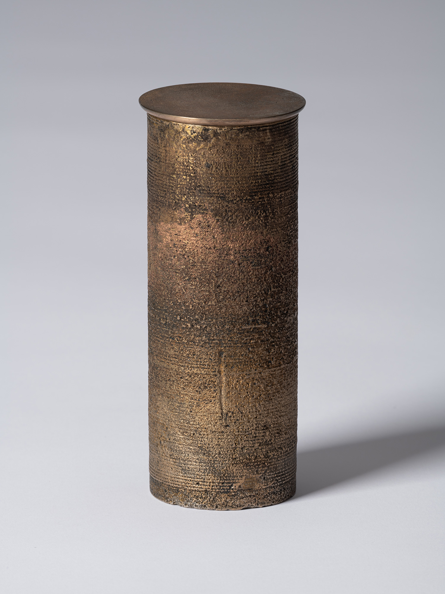 bronze as Bronze II No. 20 by Koji Hatakeyama, a tall cylindrical bronze vessel with a fitted circular...