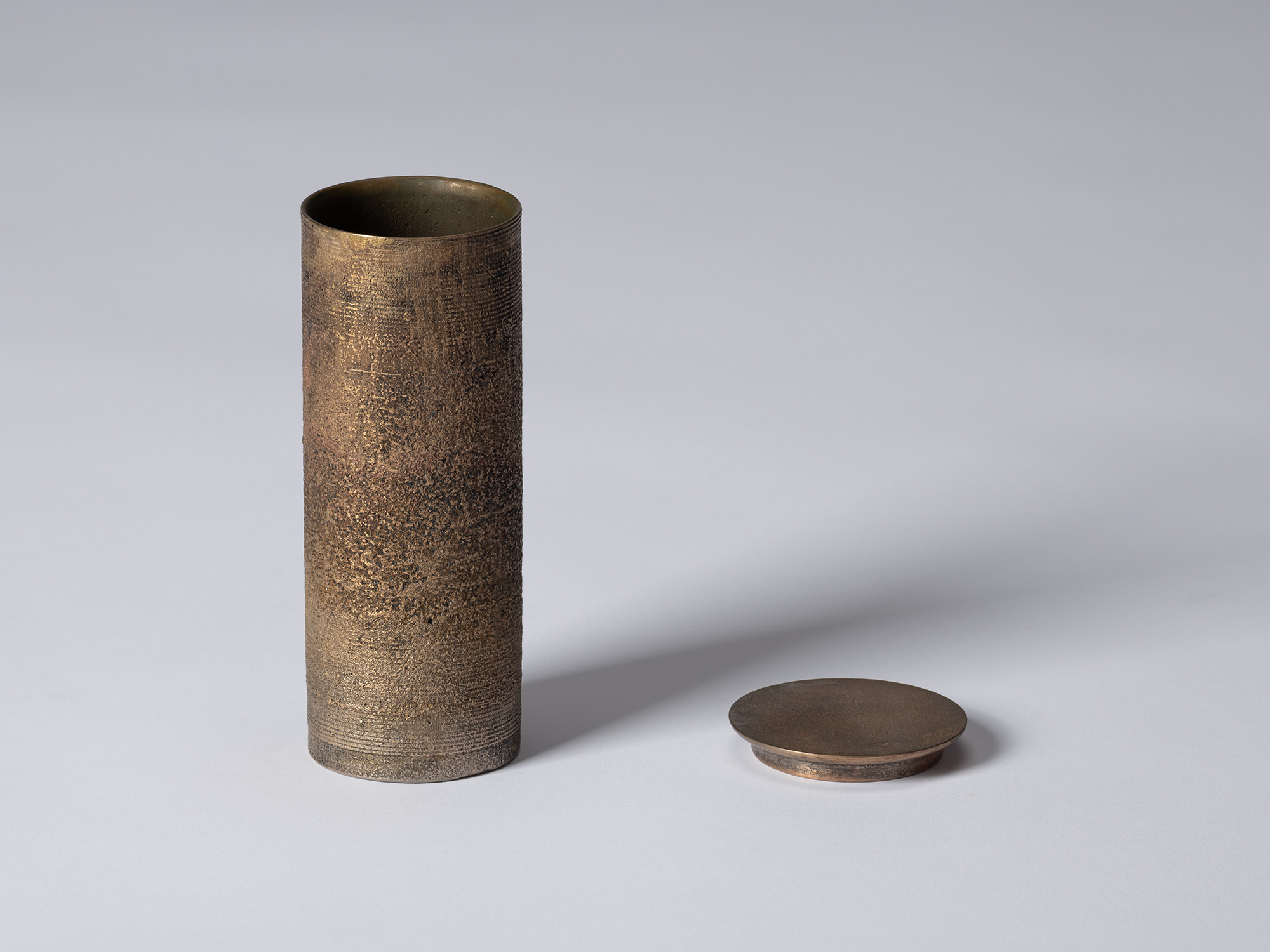 bronze as Bronze II No. 20 by Koji Hatakeyama with its circular lid removed, revealing the open...