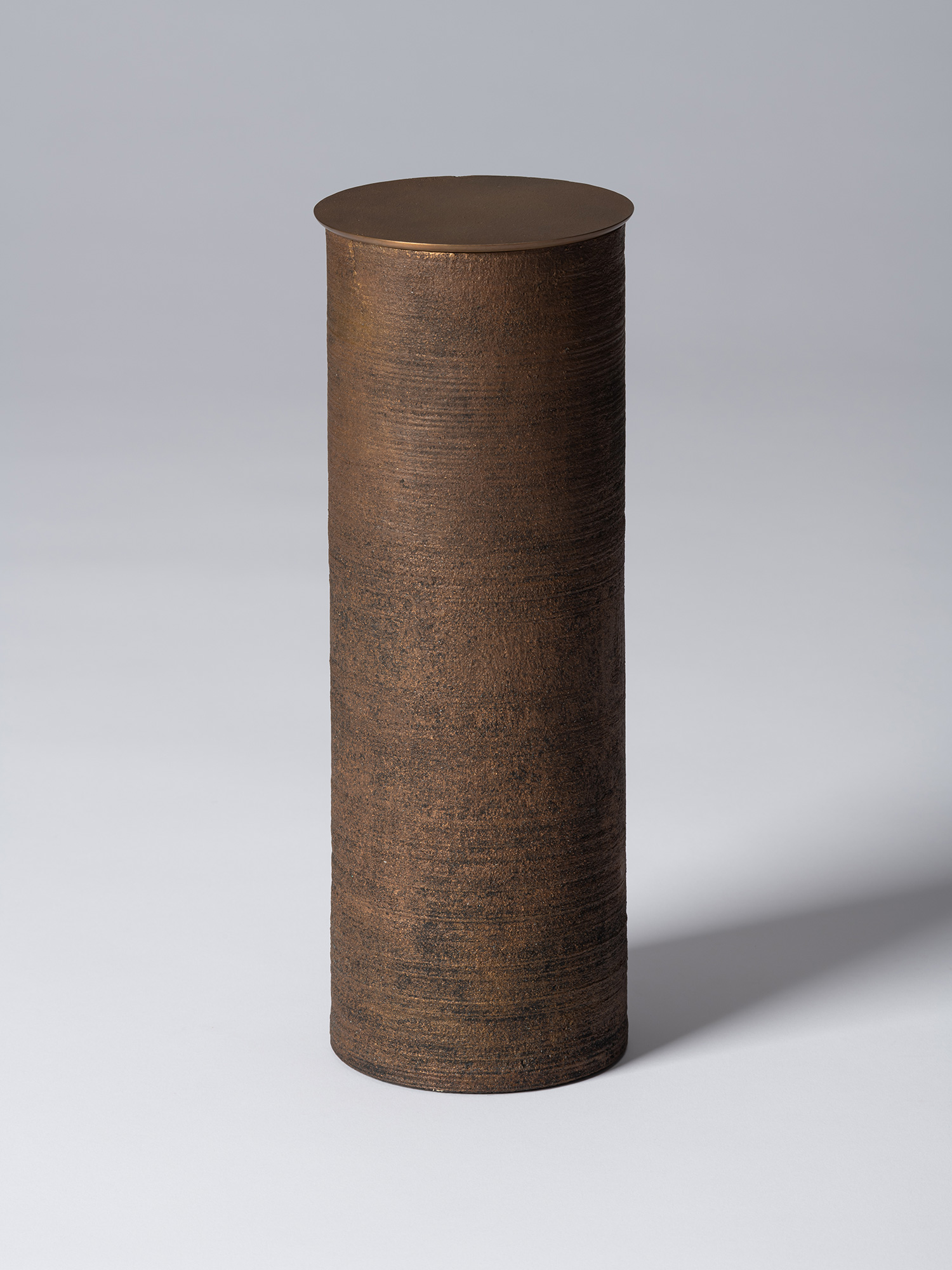 Bronze as Bronze II No. 28 by Koji Hatakeyama, a tall cylindrical lidded vessel with a dark brown...