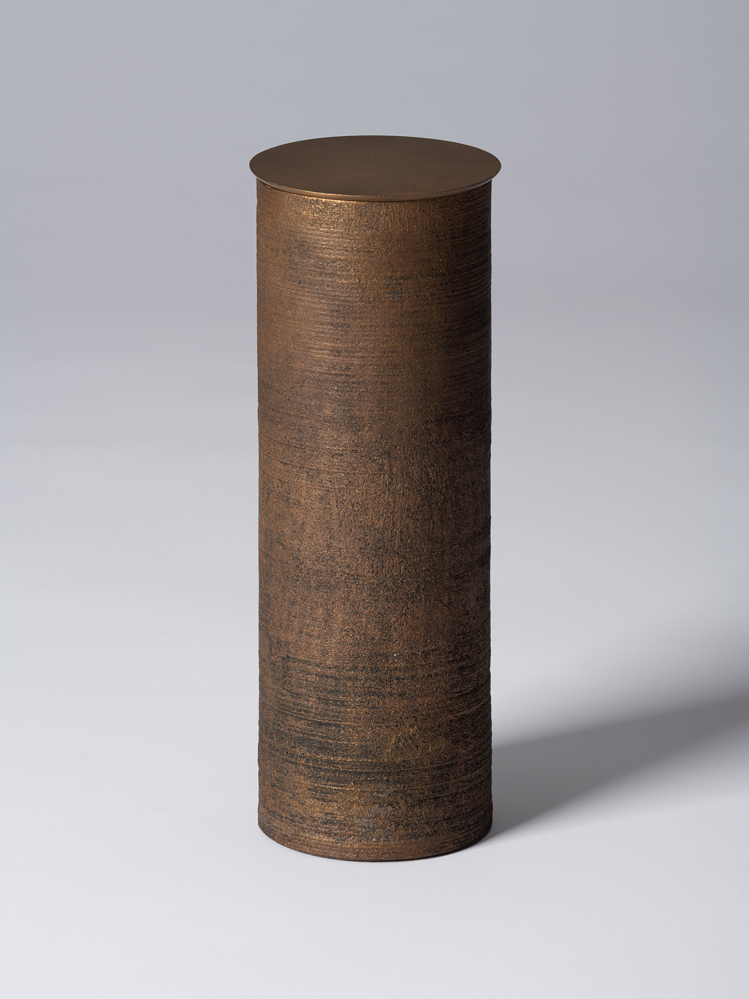 Bronze as Bronze II No. 28 by Koji Hatakeyama, a tall cylindrical lidded vessel with a dark brown...