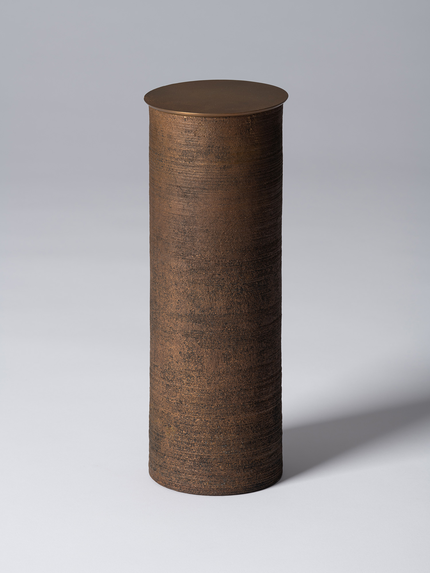 Bronze as Bronze II No. 28 by Koji Hatakeyama, a tall cylindrical lidded vessel with a dark brown...