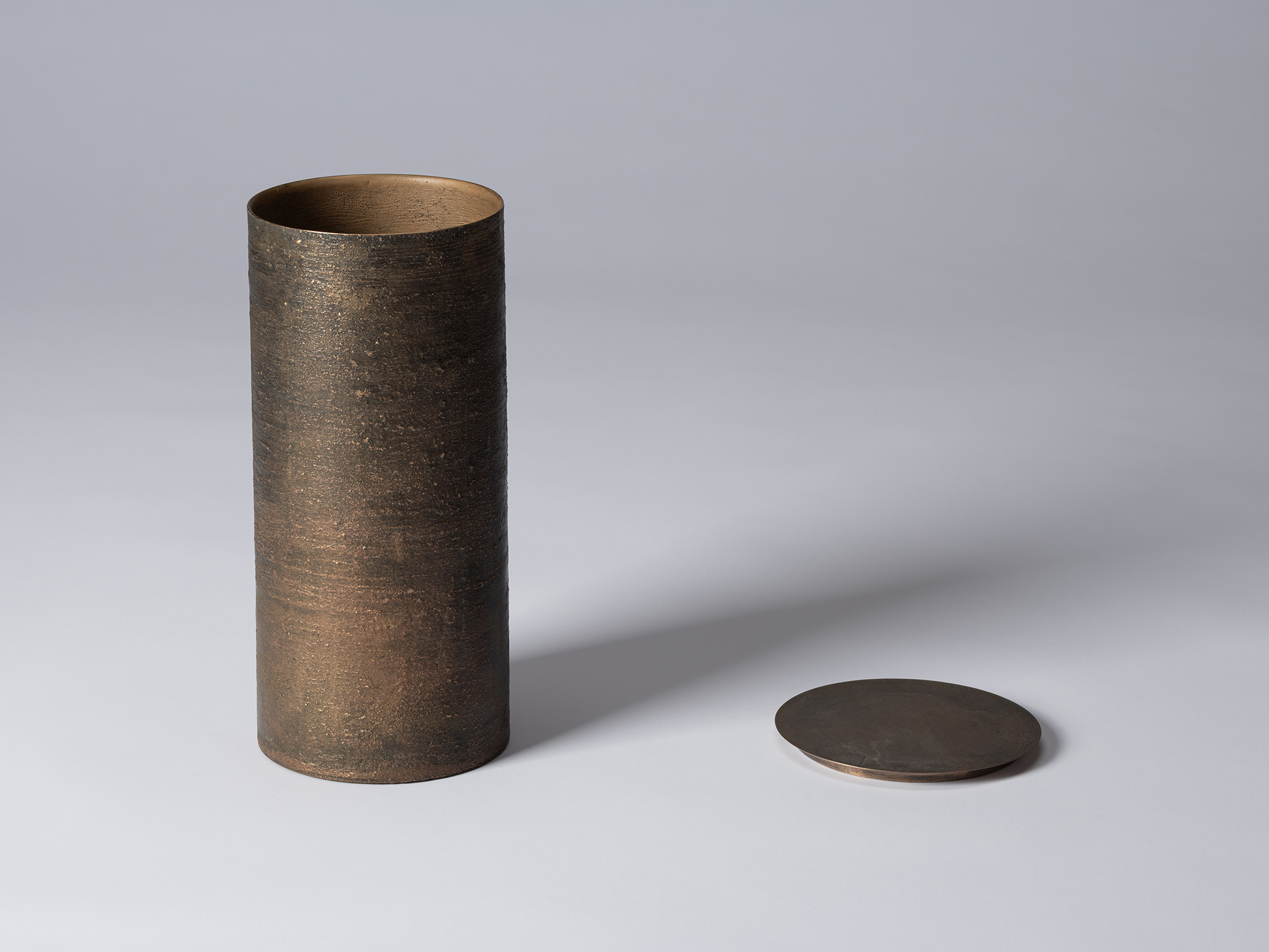 Bronze as Bronze II No. 28 shown with its lid removed, revealing the warm bronze interior; the...